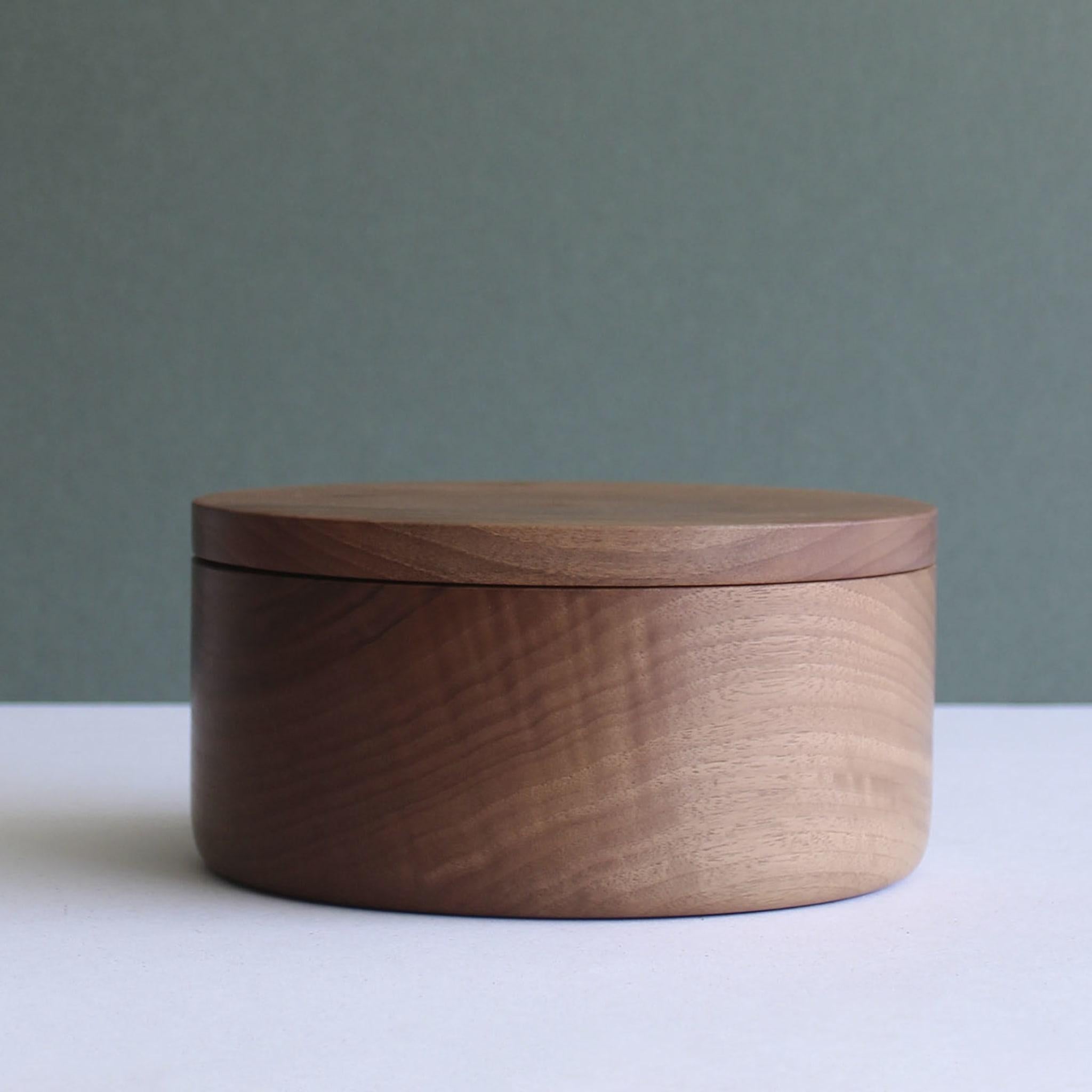 Unadorned charm gets ennobled by the presence of unpredictable natural grain in this precious cylindrical box entirely crafted by hand from solid walnut. Finished with specific food-safe oils, it makes for an elegant and practical addition to modern