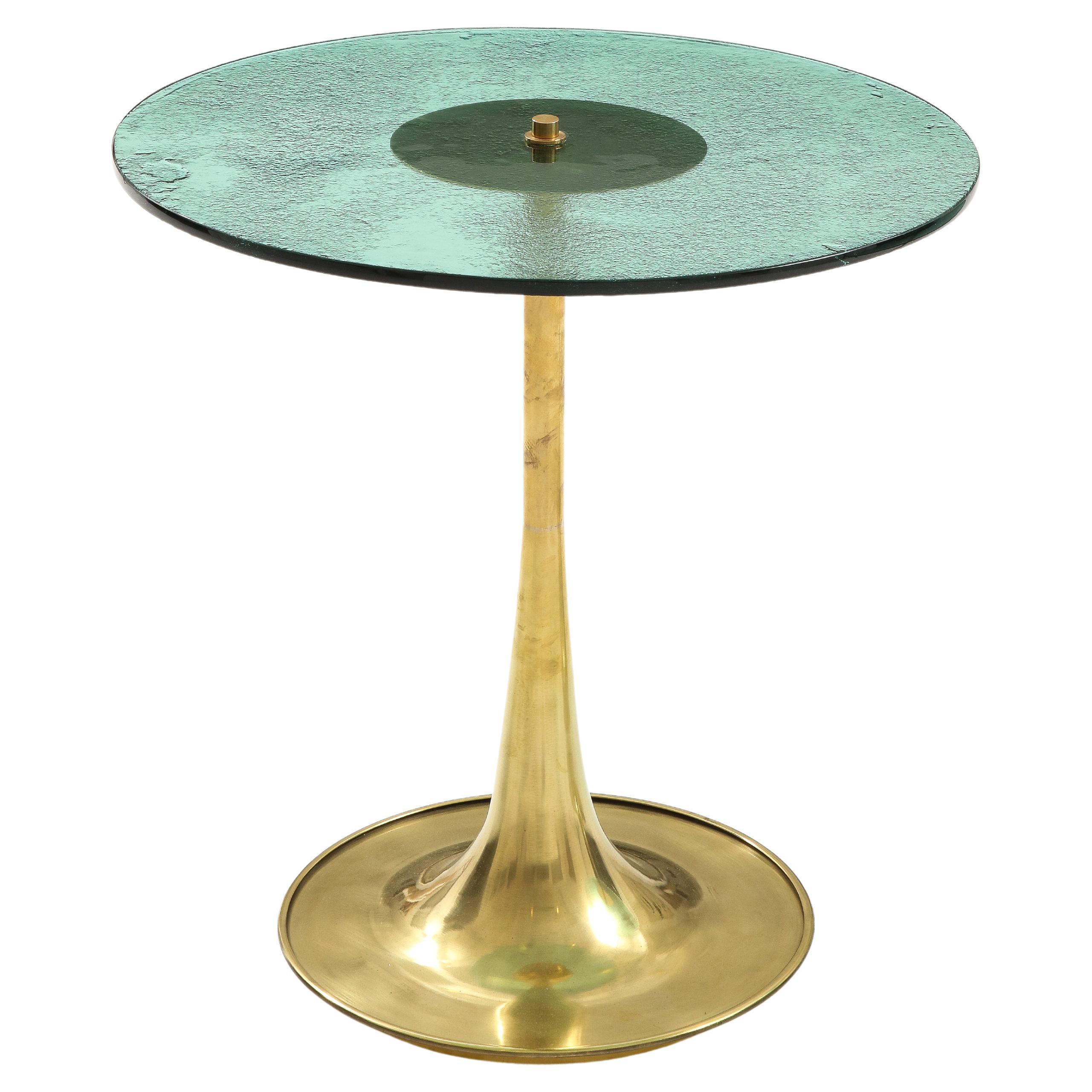 Single Round Soft Green Murano Glass and Brass Martini or Side Table, Italy, 2023. Hand-casted 12 mm Soft Green colored Murano round glass top sits atop a hand-turned, trumpet-shaped brass base. The glass top is smooth and flat on one side and