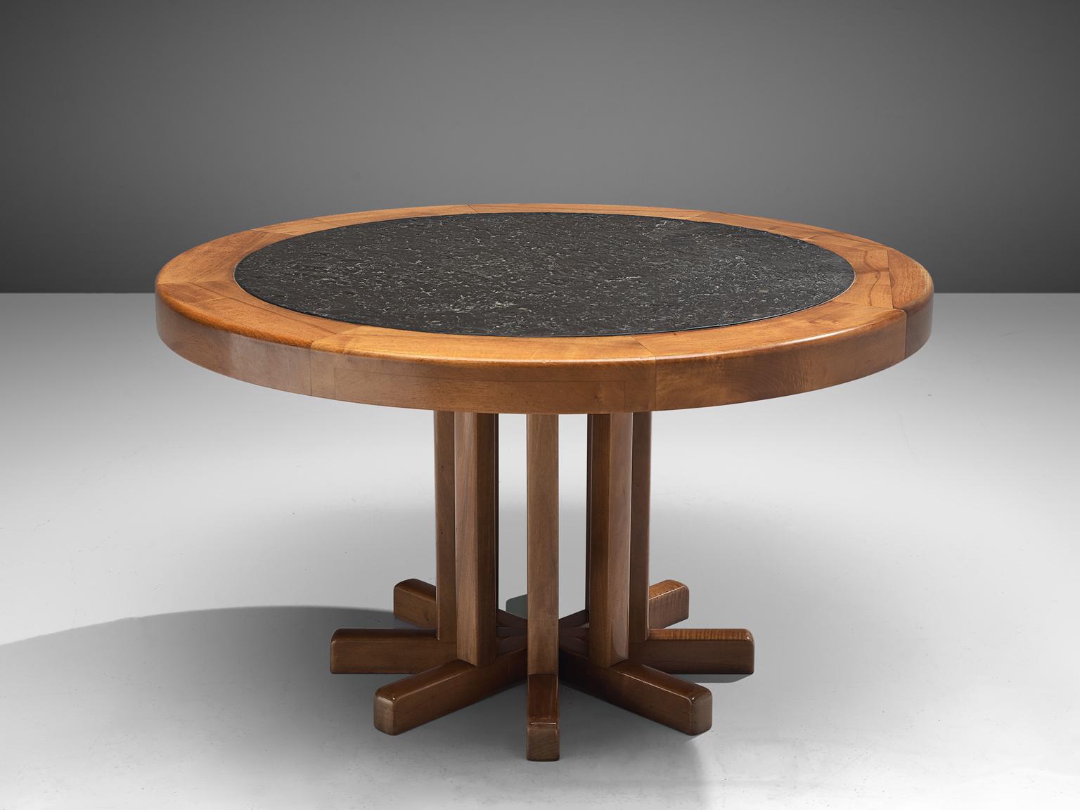 Dining table, elm and slate top, France, 1970s.

This round dining table will look wonderful in your home thanks to its sturdy appearance. The table features a base consisting of eight legs, which creates a graphical visual effect. The solid wooden