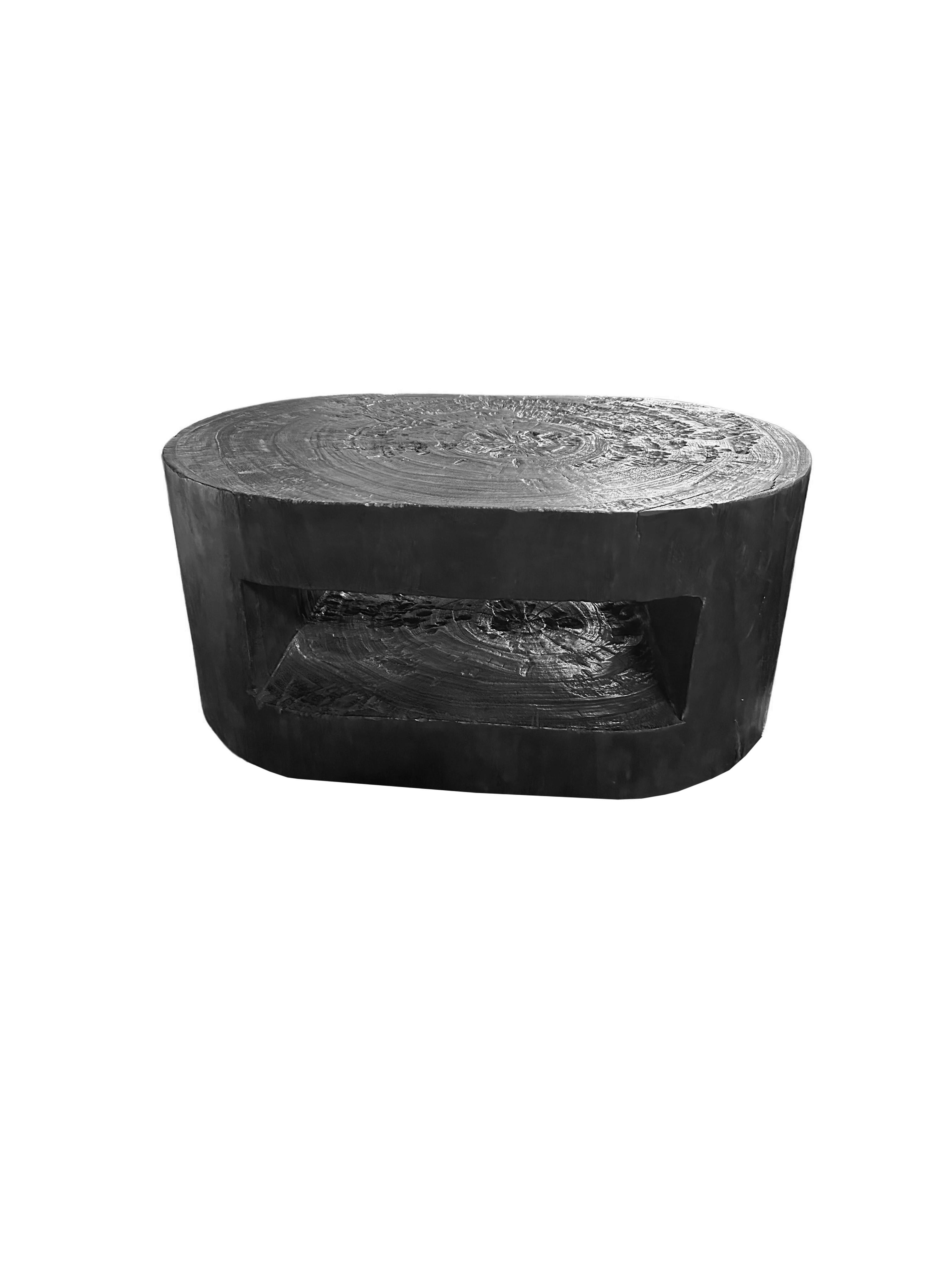Esta llamativa mesa de sofá redonda está fabricada en madera de mango, mostrando la belleza natural de las vetas de la madera y con un exclusivo acabado en negro quemado que añade un aire de sofisticación y encanto rústico. Un elemento de diseño
