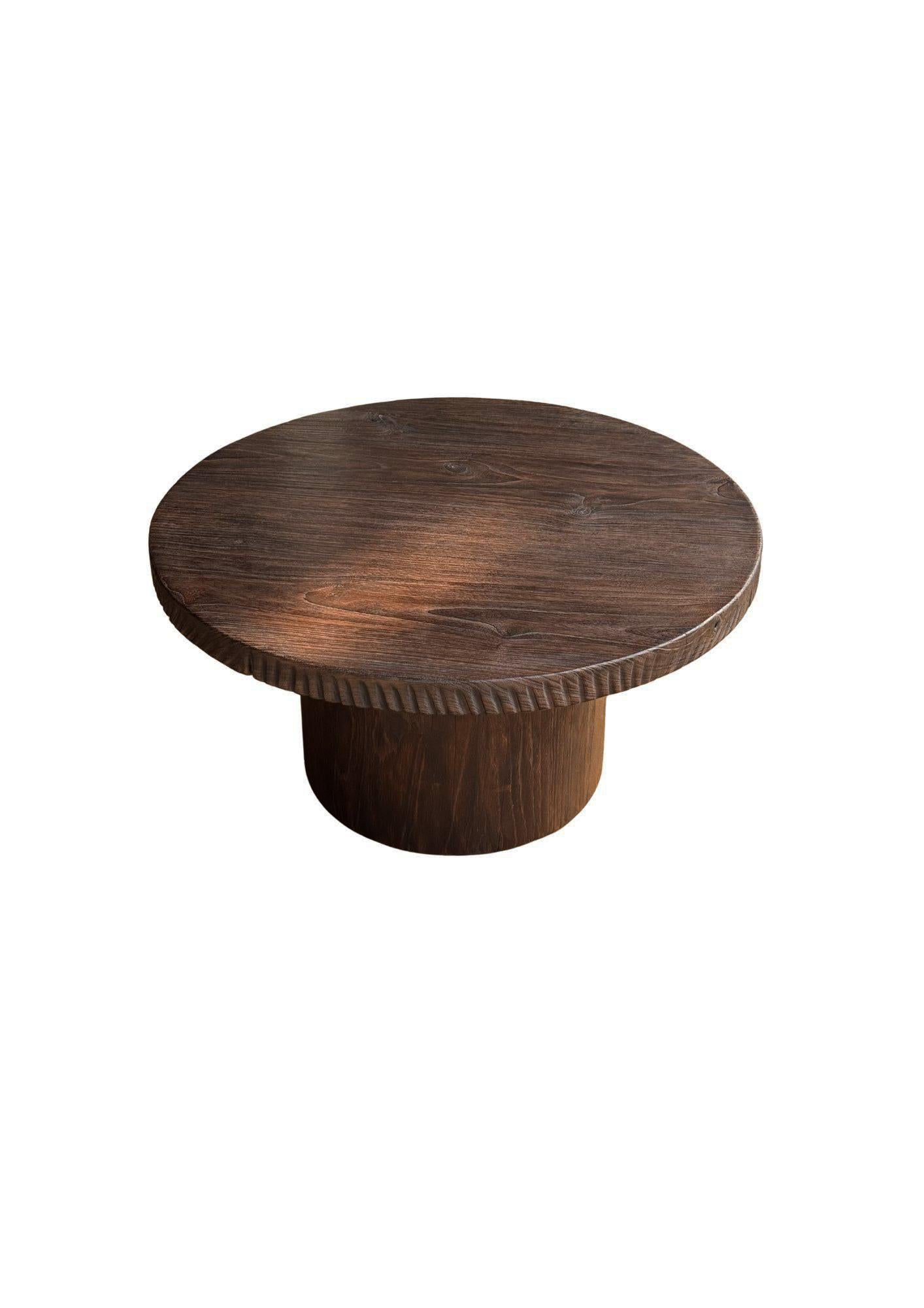 Introducing our exquisite organic Teak wood round table, beautifully crafted with a striking burnt finish that enhances the natural beauty of the wood. This stunning piece showcases a rich array of textures and shades, highlighting the unique grain