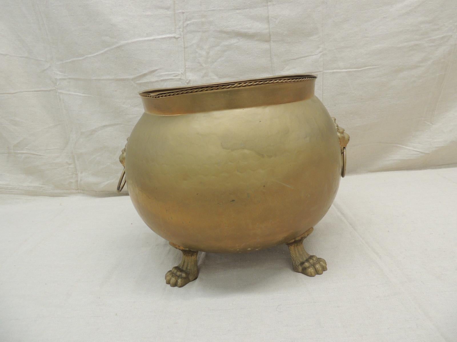 Round Spanish Cauldron fireplace log brass lion paws and lion heads.
Measures: 14” D x 10.5” H.
 