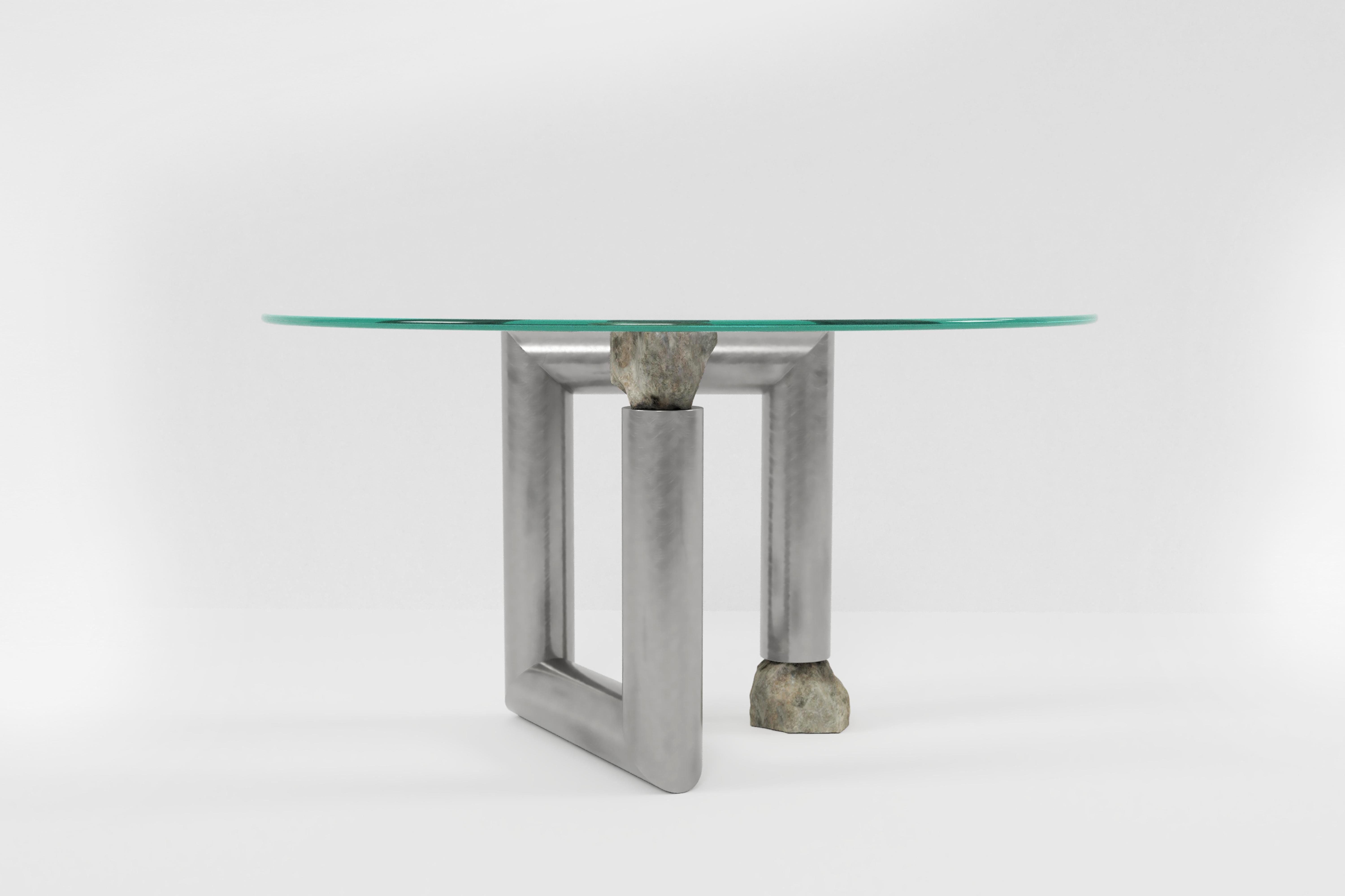 Round stainless steel dining table by Batten and Kamp
Limited edition of 24 + 3 AP.
Dimensions: Diameter 140 x H 73 cm 
Materials: Hand-brushed stainless steel, toughed glass, granite stone.

The top can be made to the buyer's preference.

Batten