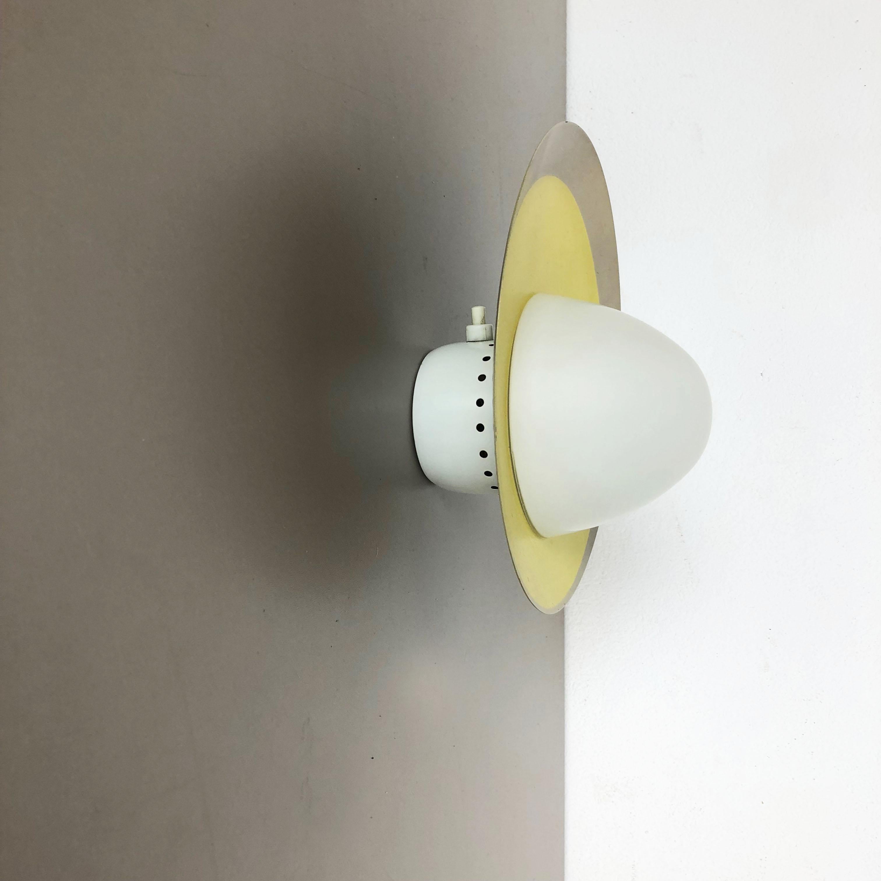 Article:

Wall light sconces with opal glass shade.



Origin:

Italy



Age:

1960s.



Original 1960s modernist Italian wall light made of solid metal in original yellow tone finish and opal glass element in the middle. The