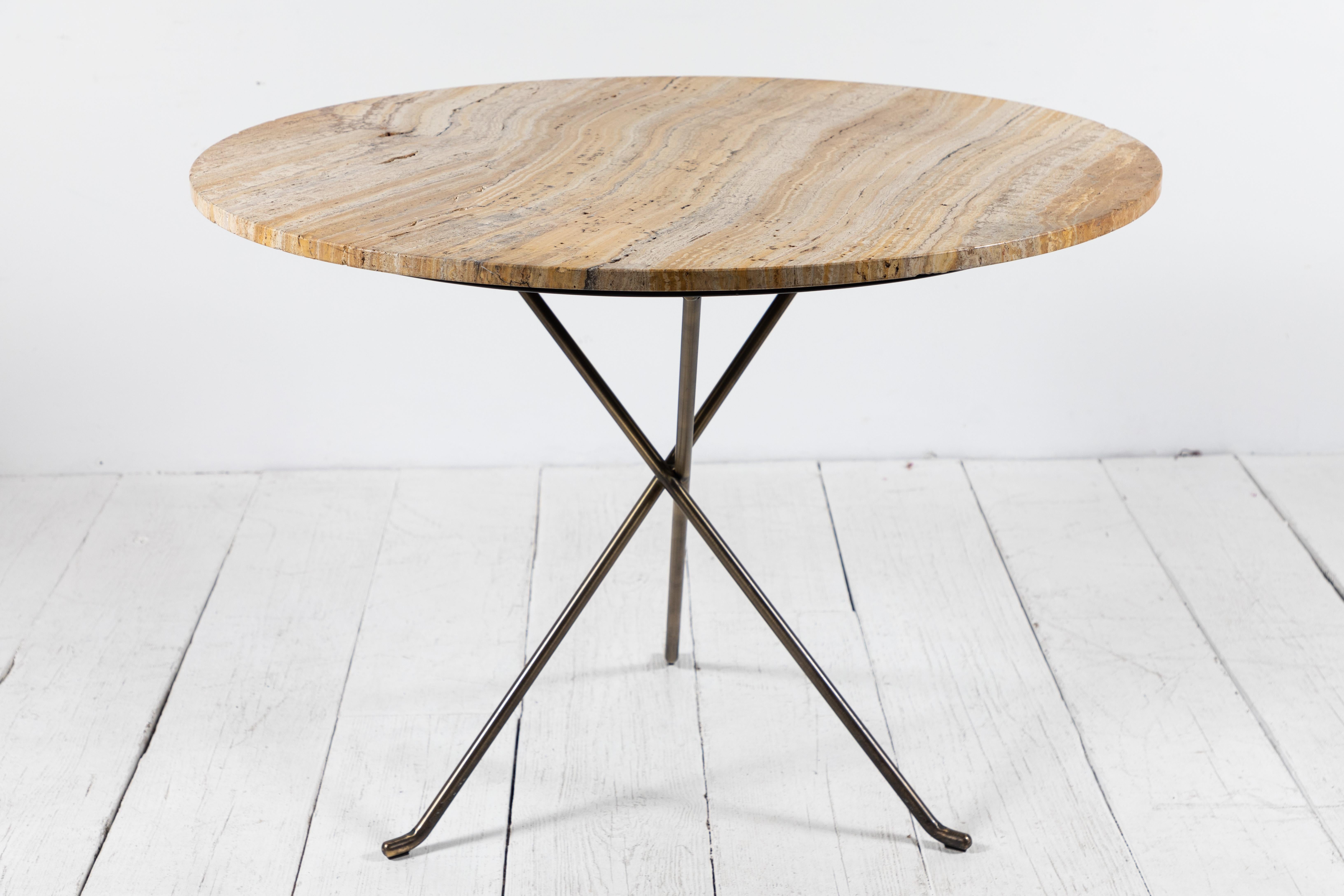 Round travertine stone top on three legged metal base. The stone top has unique formations.