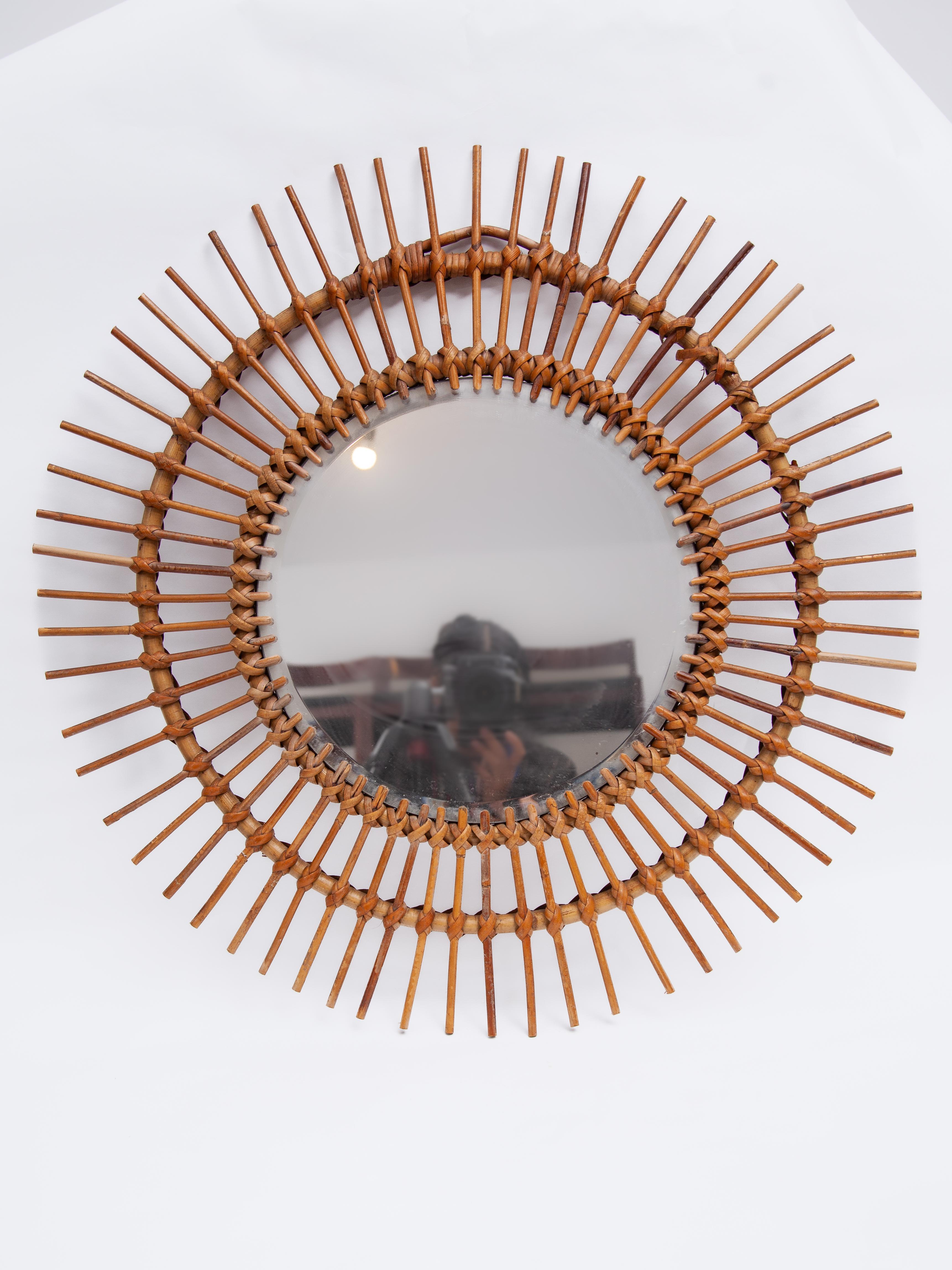 Midcentury French rattan sunburst mirror, 1950s. A vintage collectible classic. The mirror is in good condition with a characterful patina frame. A decorative wall hanging sunny piece.
