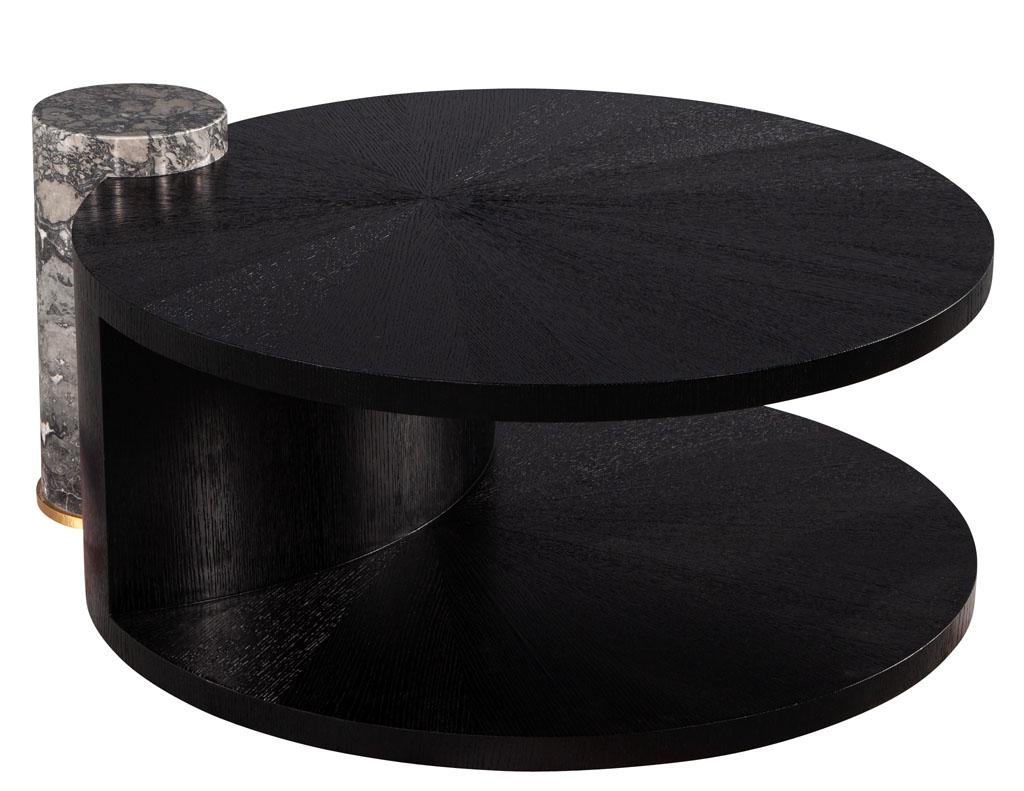 Round Sunburst oak marble pedestal black cocktail coffee table. Unique coffee cocktail table with a cerused oak sunburst top finished in a wire brushed ebonized finish adorned with a marble pilaster on top of a brass ring. Space between lower shelf