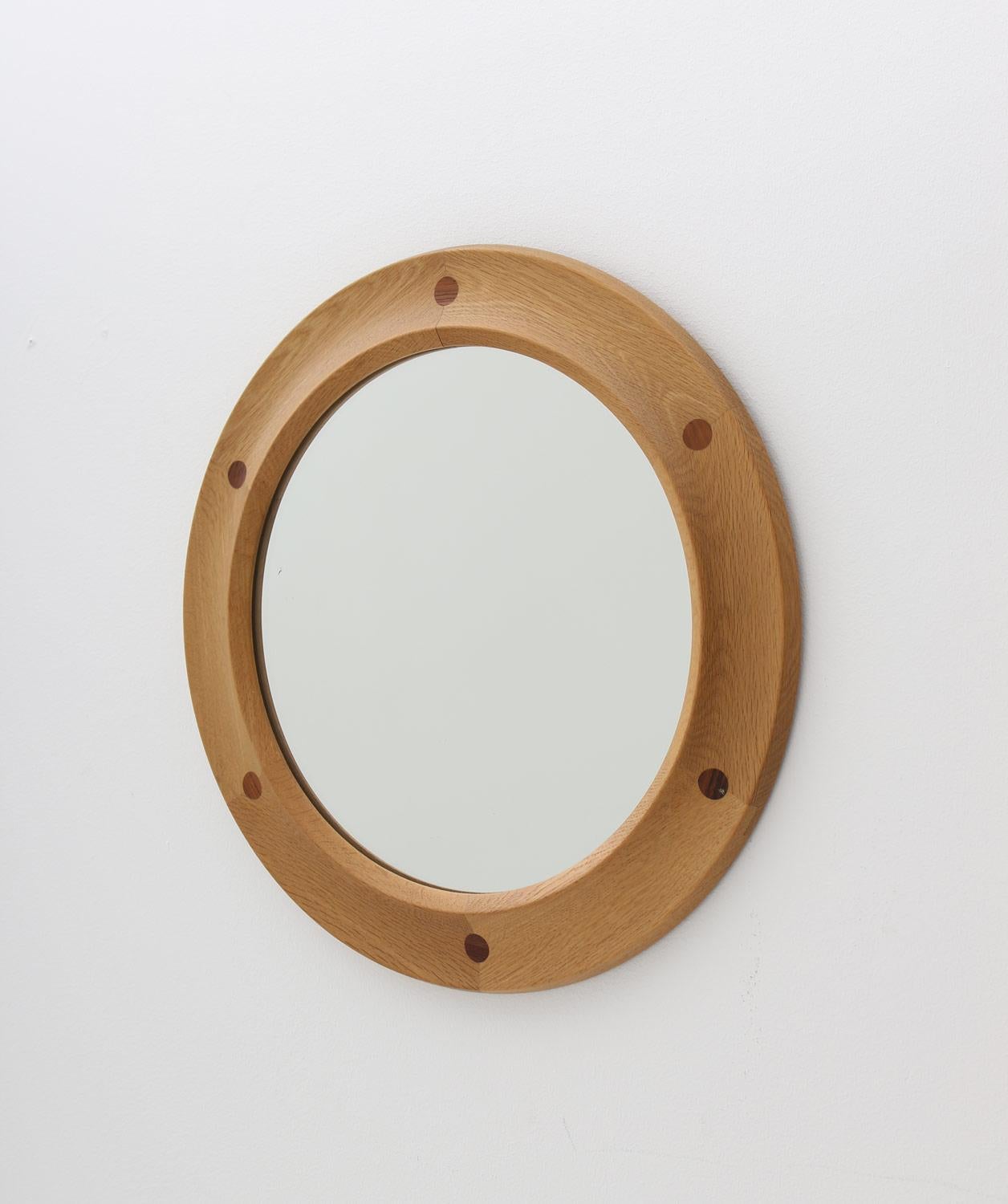 Beautiful midcentury round mirror by Nybrofabriken Fröseke, Sweden.
The mirror is made in oak with beautiful details in rosewood. 
Condition: Excellent condition on the frame, minimal signs of age on the mirror glass.
 