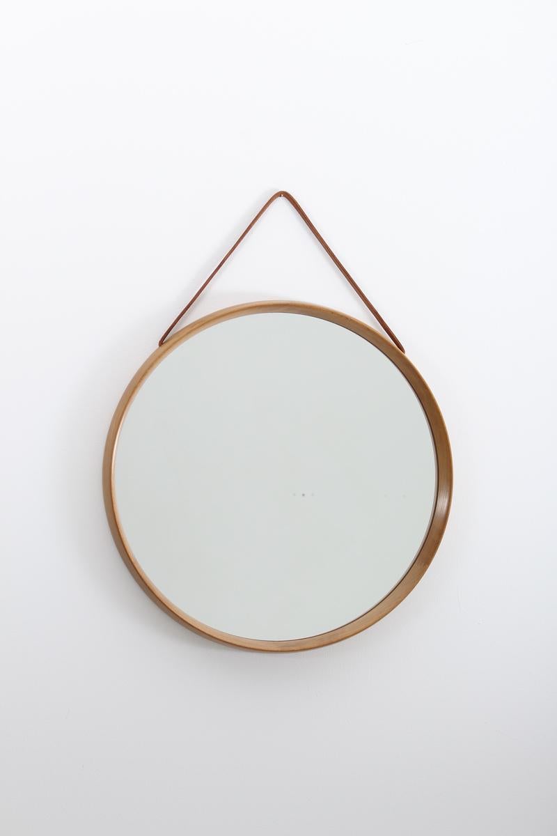 Beautiful midcentury round mirror by Uno & O¨sten Kristiansson for Luxus, Sweden.
The mirror is made in oak and hangs in a leather strap.
Condition: Excellent condition on the frame and strap, signs of age on the mirror glass.
 