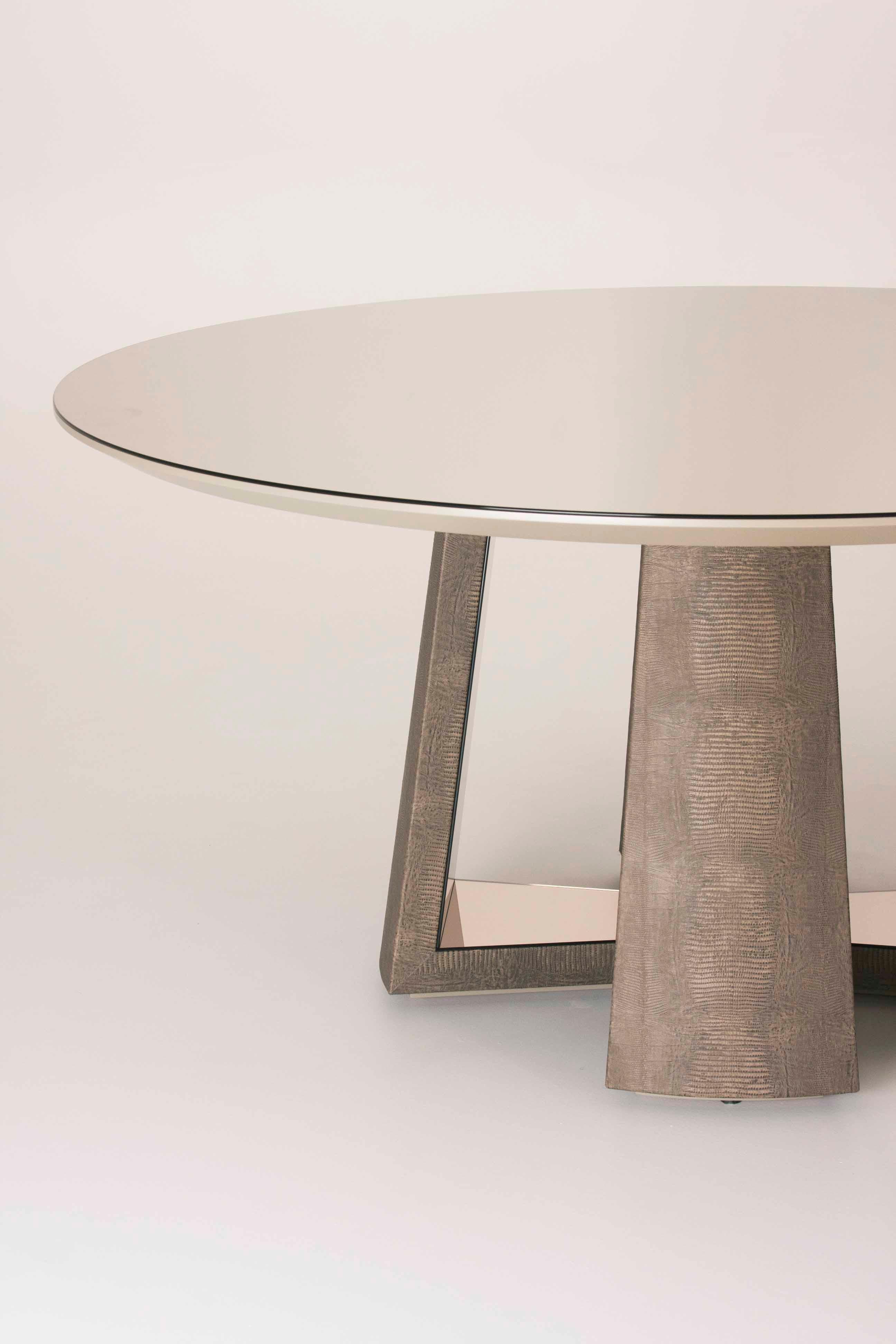 Perfection is the right word for this round table with base coated in leather and mirror. Measure: 160 cm.