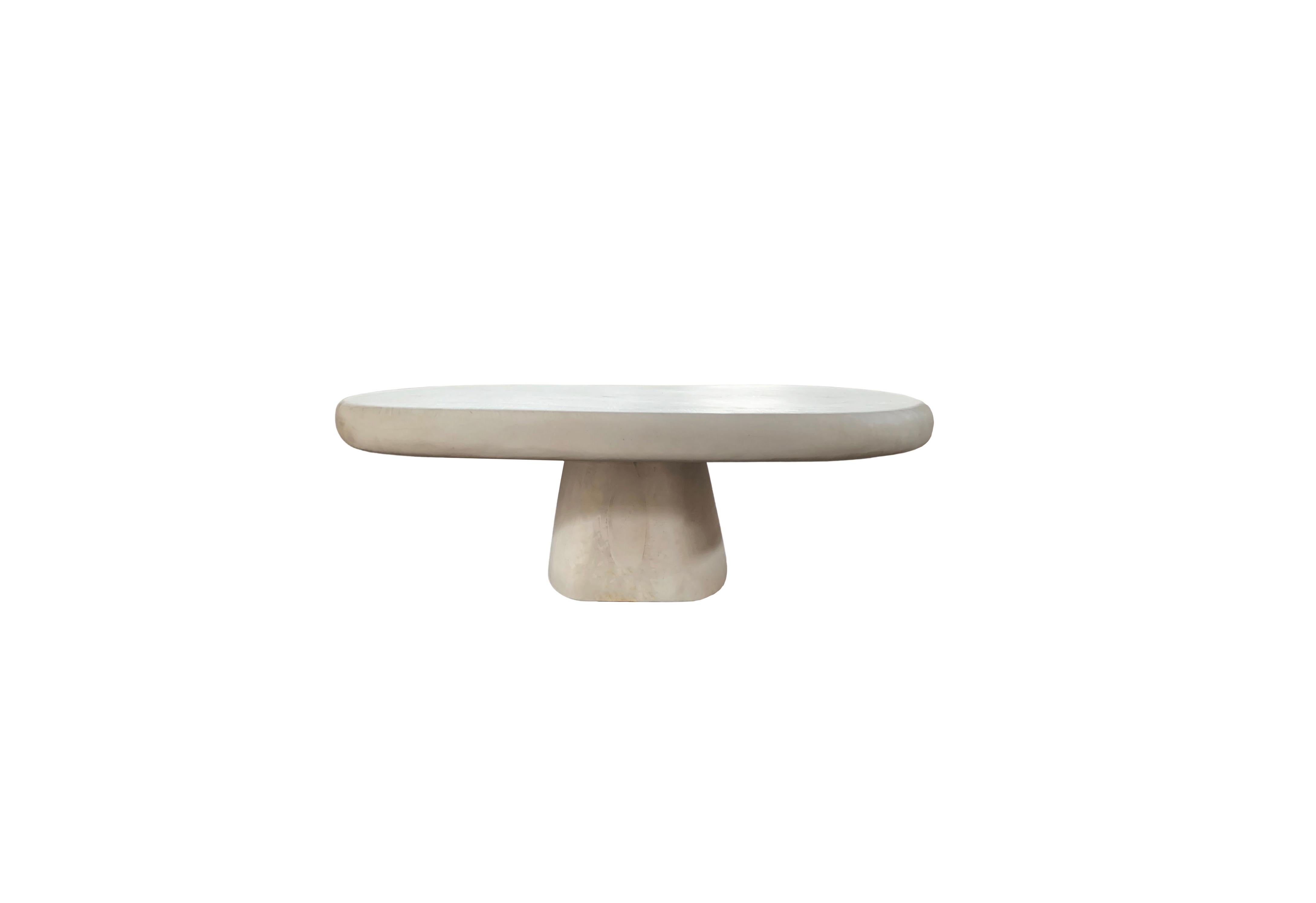 A sculptural round side table with a neutral pigment and subtle wood texture. A uniquely sculptural and versatile piece certain to invoke conversation. It was crafted from a solid block of mango wood. It features a bleached finish to achieve its