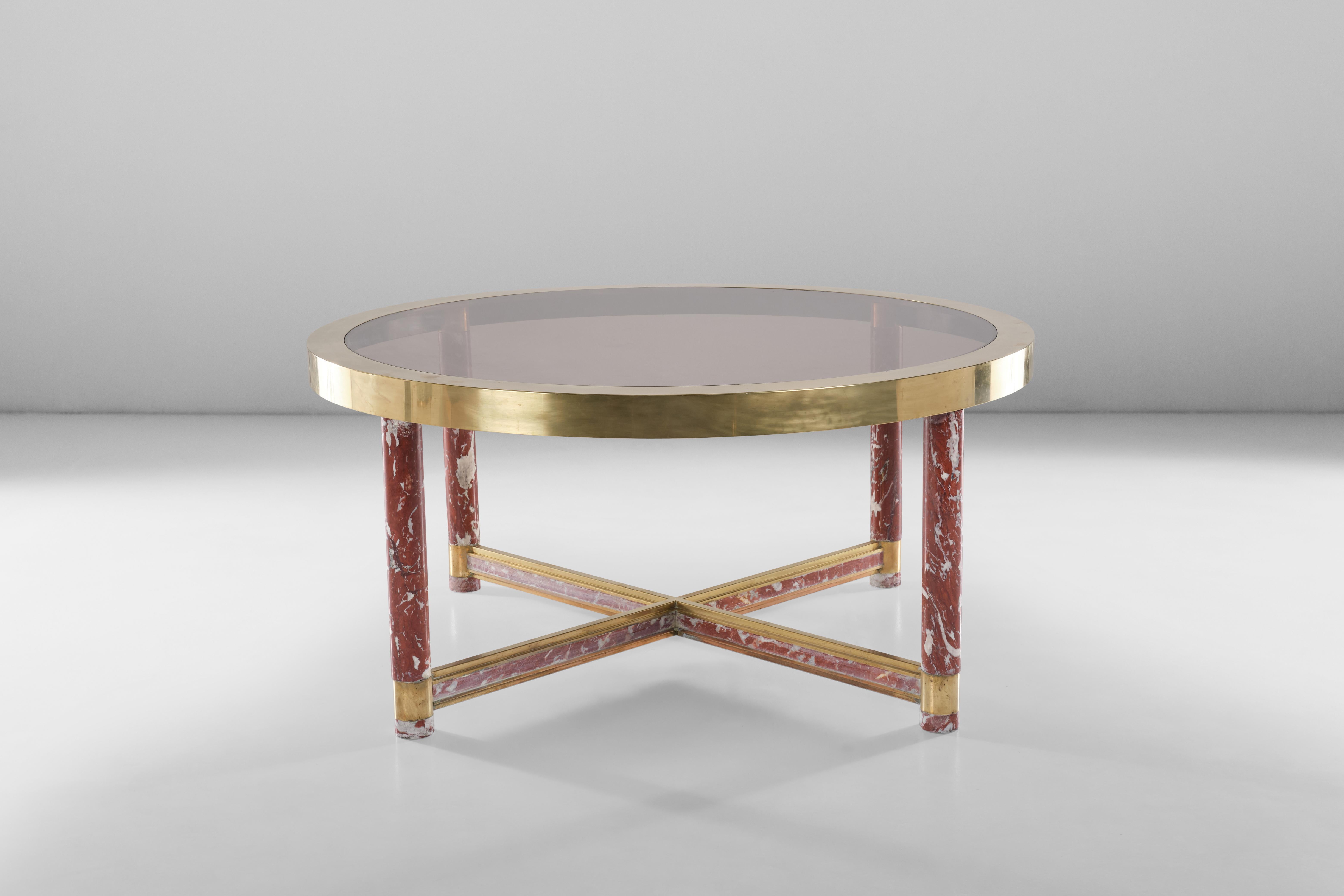 Cette grande table ronde conçue par Sandro Petti pour Metalarte équilibre parfaitement tous ses matériaux, du marbre rouge au laiton et au verre, pour conférer un aspect raffiné à votre pièce.