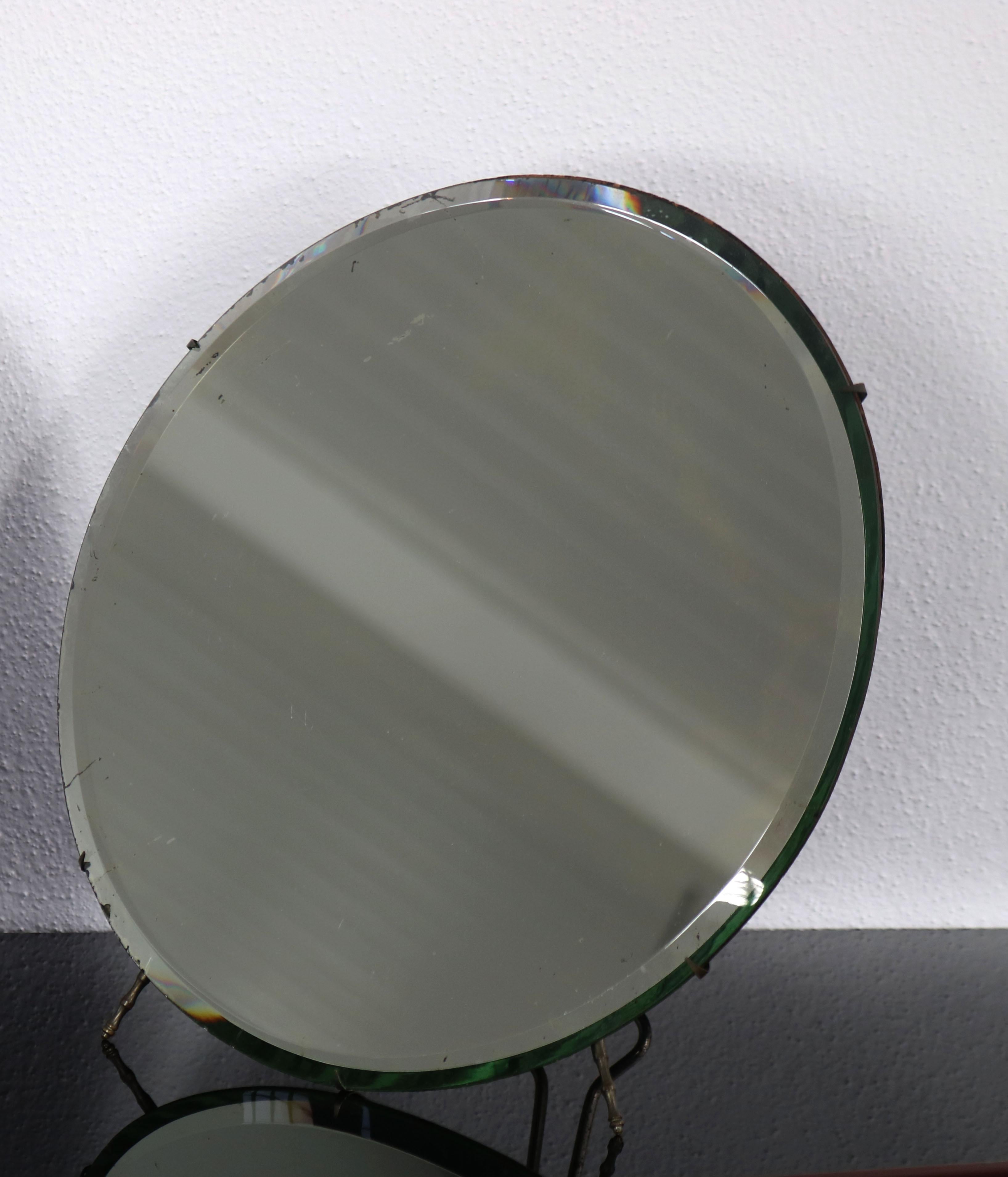 Simple round table mirror of Luigi Fontana & C, Italy 1950s. The table mirror owns some traces of time and usage, which do no harm to the charm of the mirror. 

