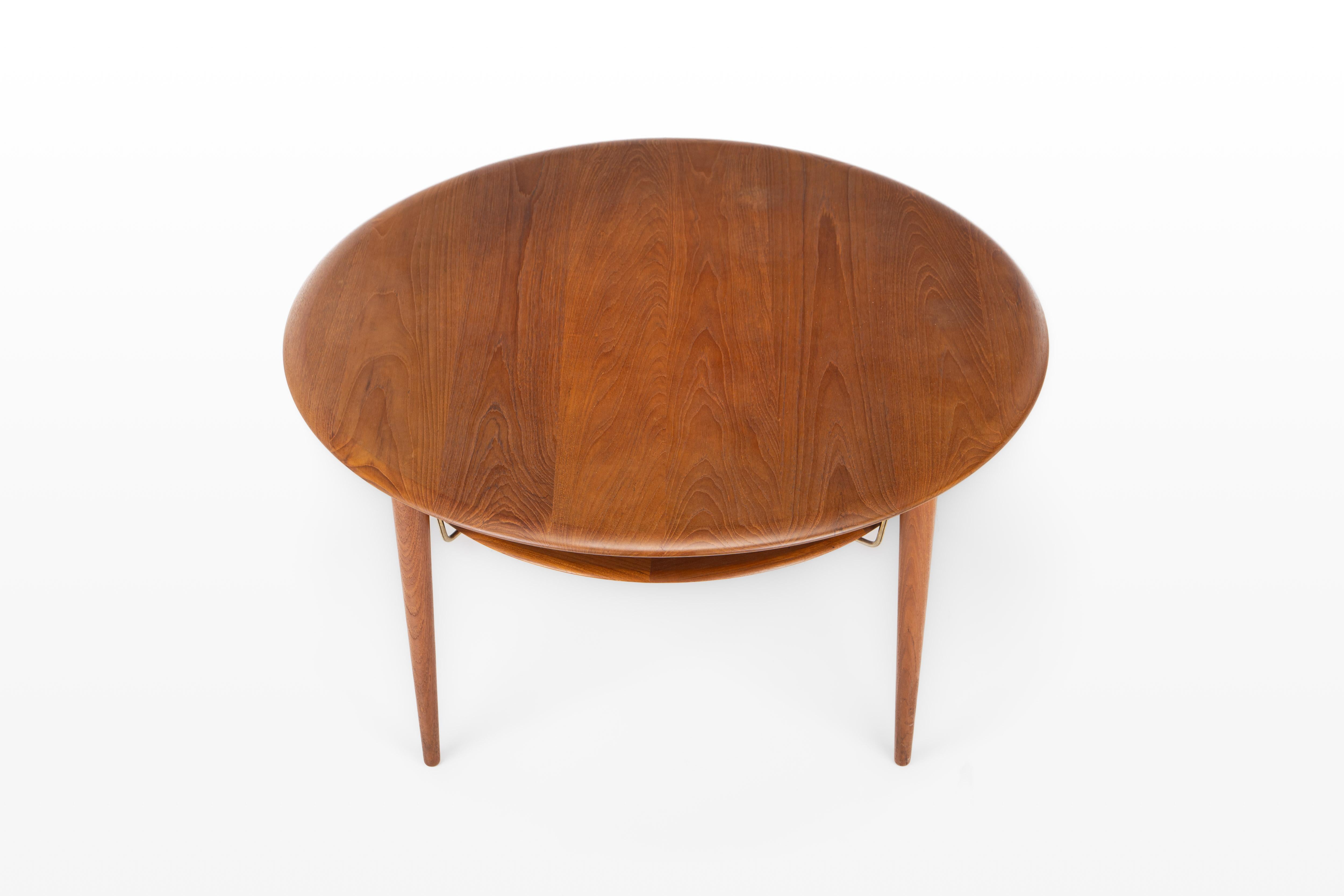 Beautiful round coffee table designed by Peter Hvidt & Orla Molgaard Nielsen and manufactured by France & Son, Denmark 1960s. The table is made of teak and cane, with nice details in brass. The table is marked by the manufacturer.