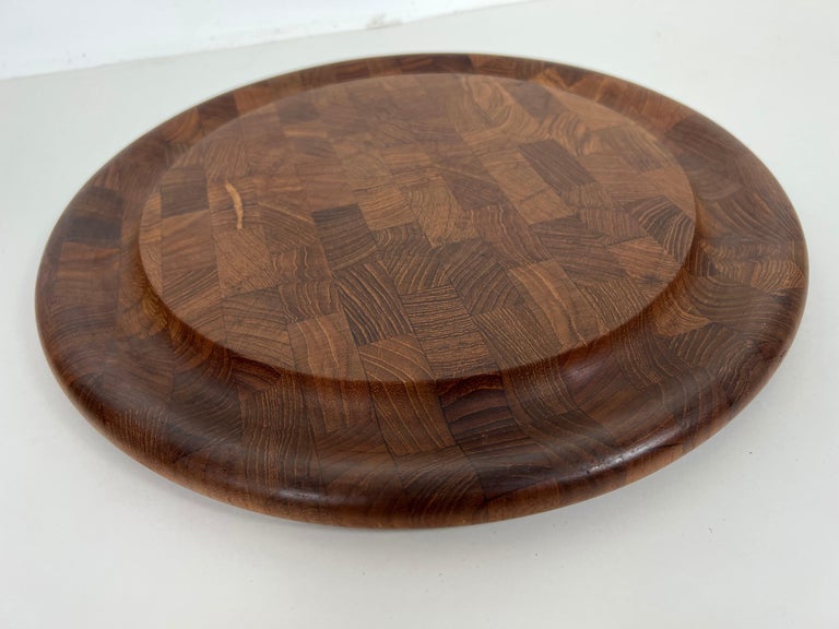 Vintage round cutting board in end-grain teak by Jens Quistgaard for Dansk. Recessed, grooved edges serve well for cutting roasts or other cooked meats. Also great for use a charcuterie or serving board. Marked 