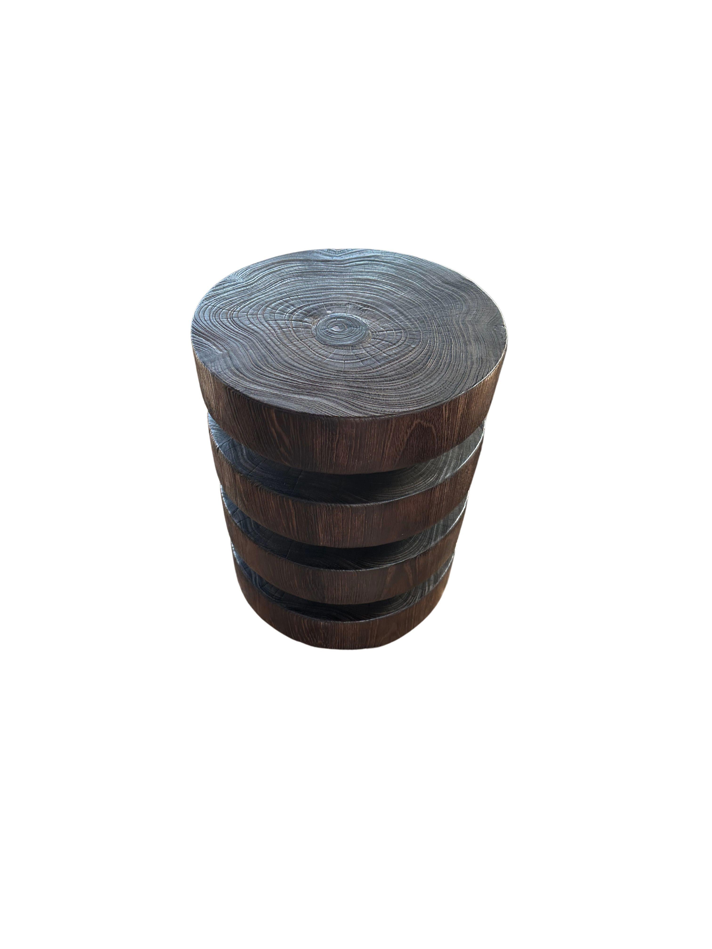 A wonderfully sculpted side table, crafted from a single block of teak wood. It features wonderful wood textures as well and carved detailing that wrap around its sides. To achieve its pigment the wood was burnt several times and finished with a