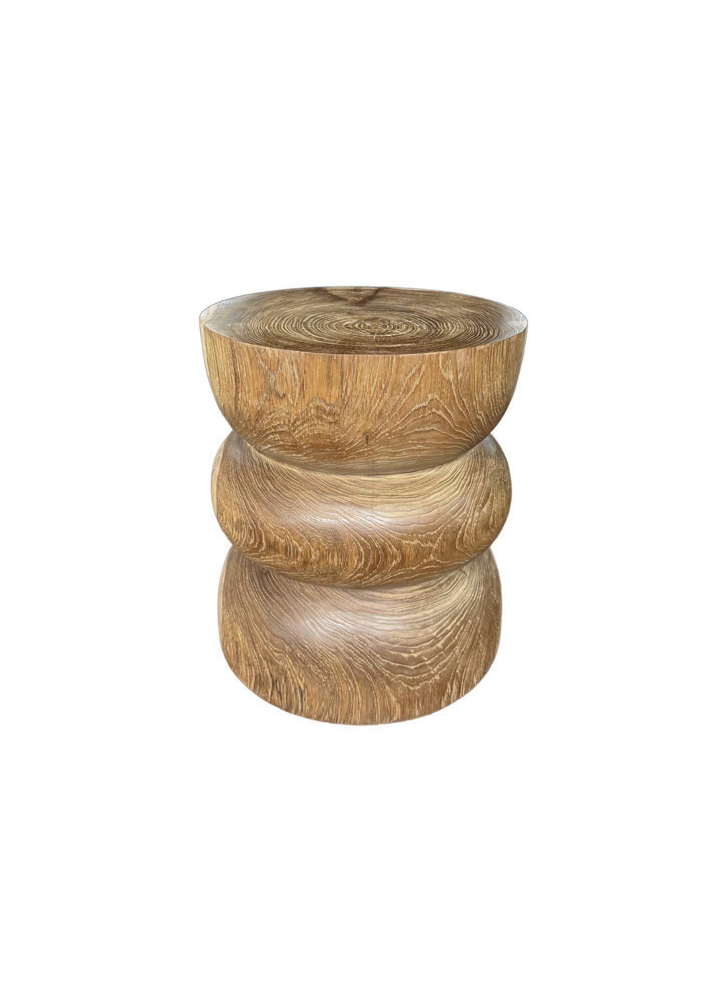 Eleva tu espacio con la belleza natural y la elegancia atemporal de esta mesa auxiliar de madera de teca maciza, elaborada con maestría a partir de un único bloque de teca de primera calidad. Con contornos de madera orgánicos y sorprendentes y ricas
