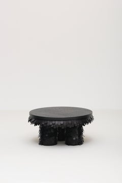 mesa de centro redonda de cuero negro orgánico texturado y madera