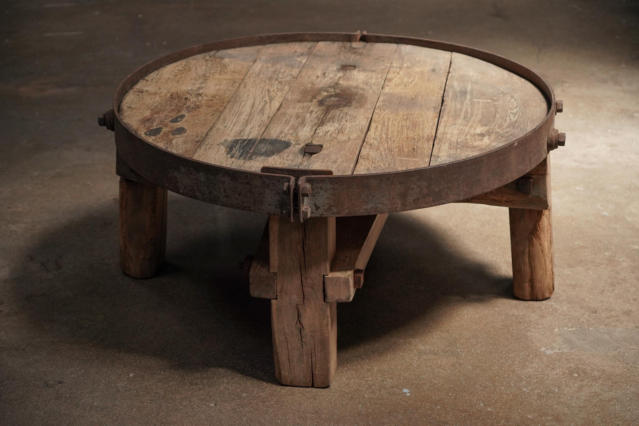 Cette table basse allie un plateau circulaire en bois à un cadre en fer. Son design simple, sa belle patine et ses matériaux durables le rendent à la fois fonctionnel et polyvalent.