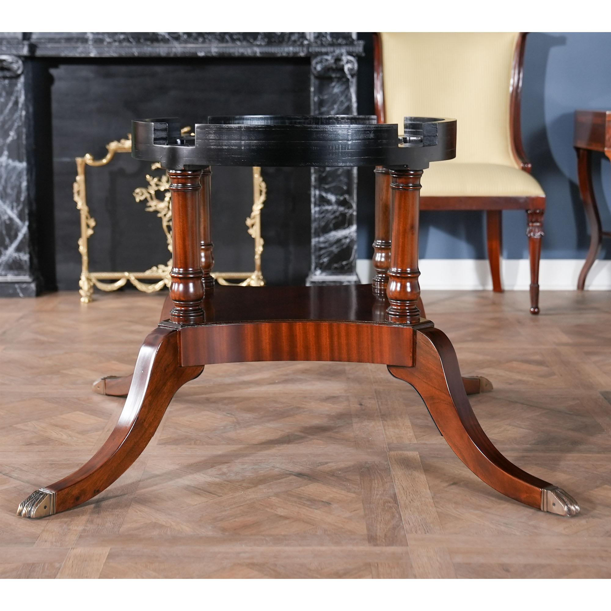 Cette table ronde à périmètre ovale de 60 pouces est fabriquée à partir d'un champ d'acajou figuré de haute qualité et de bandes de bois satiné qui créent un contraste audacieux et intéressant dans le motif du plateau de la table. Autour du plateau