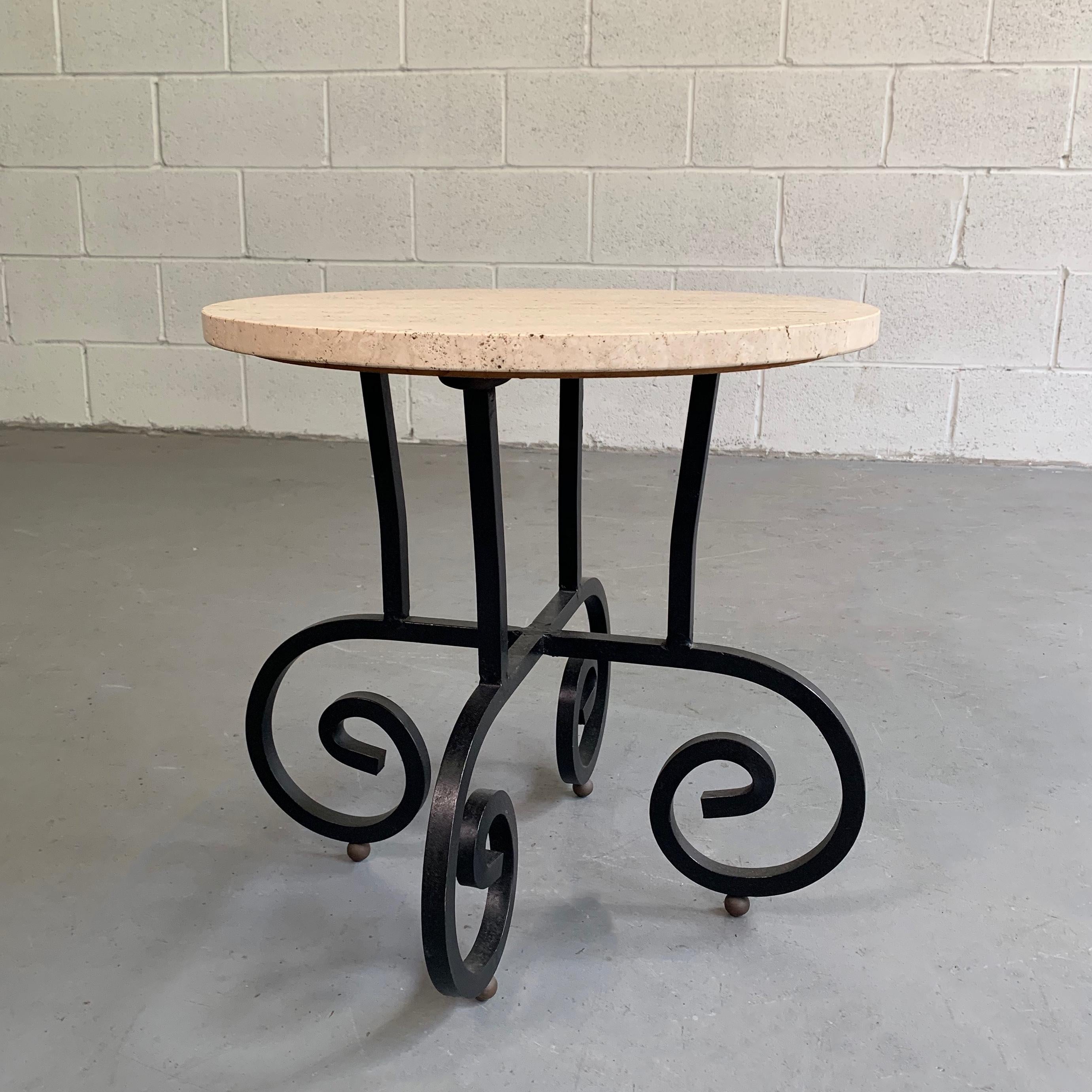 Hollywood regency side table features a round travertine top with scrolled wrought iron base.