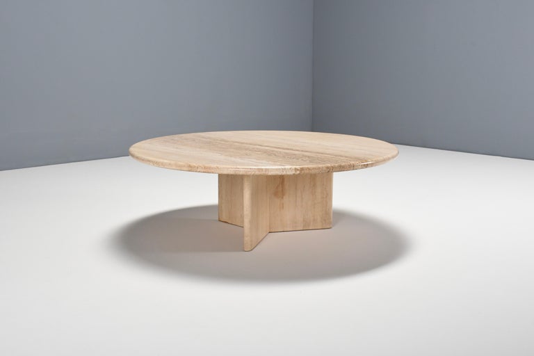 Round travertine coffee table in very good condition. 

The table has a round travertine top. 

The base is formed of three slabs of travertine, which combine into star shape. 

The bas and top are connected to each other.

The travertine surface is