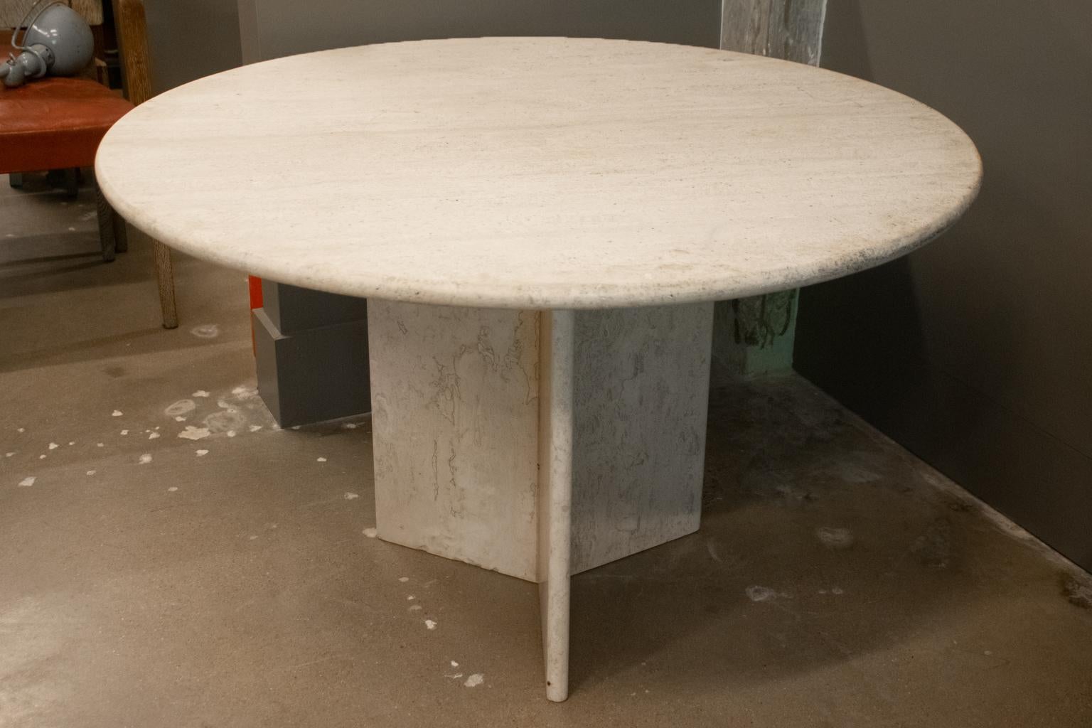 Solid travertine dining table with round top and three sided base, Italy, 1960-1970.  Professionally honed and sealed. 