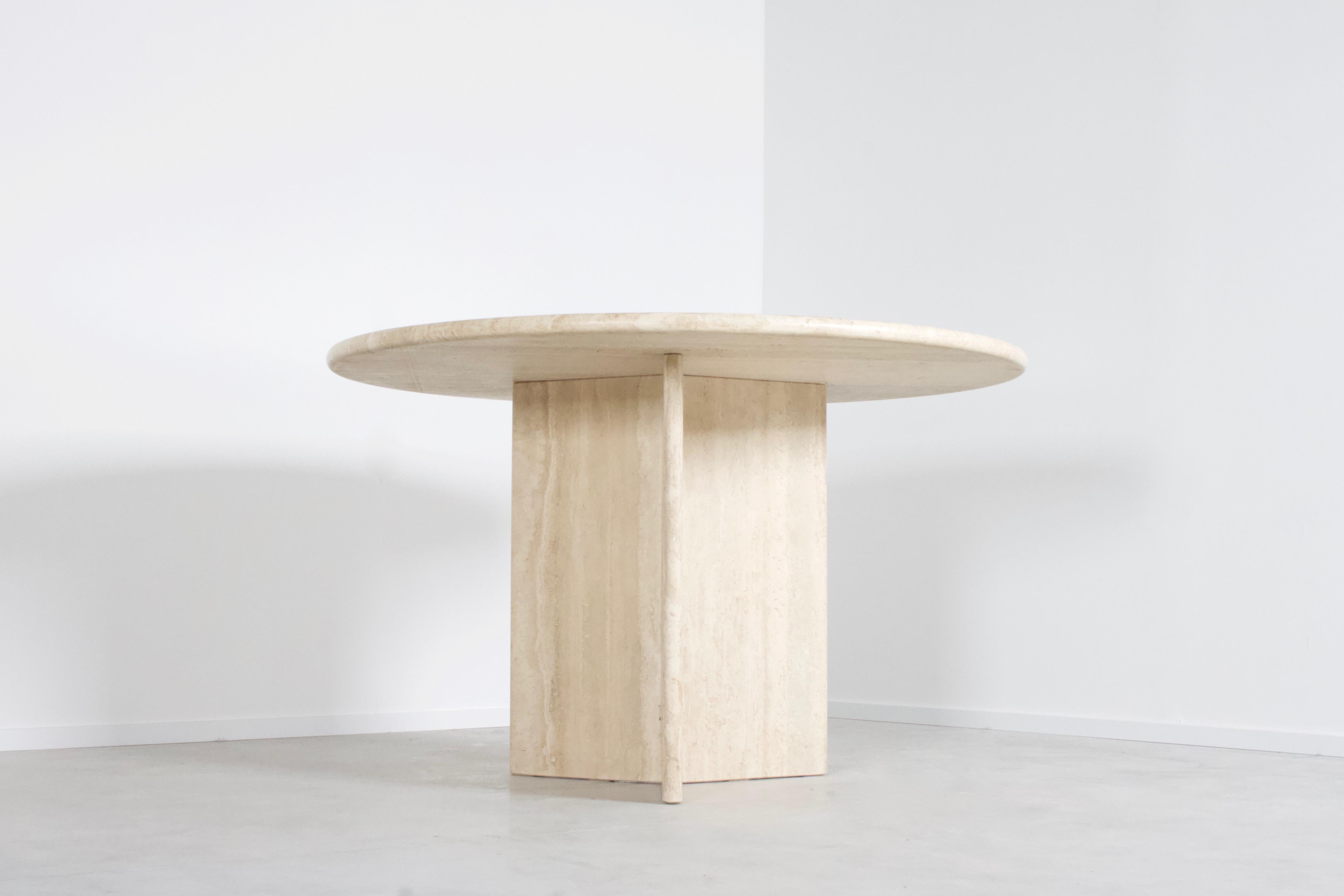 Round travertine dining table in very good condition.

The table has a round travertine top.

The base is formed of three slabs of travertine, which combine into a triangle or star shape.

The travertine surface is absolutely breathtaking and