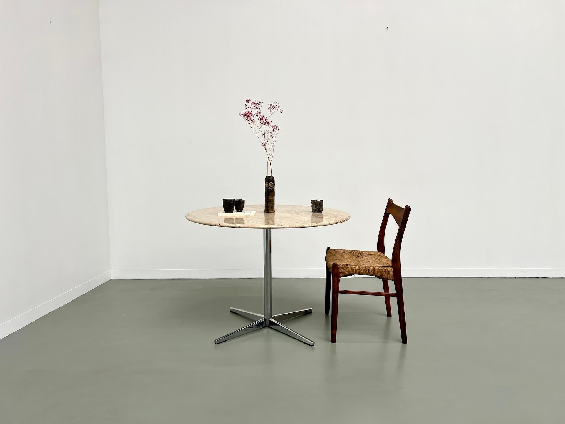 Round dining table from the 1970s. Star-shaped chrome-plated metal base supports the travertine marble top in shades ranging from beige to off-white, offering absolutely stunning nuances. Entirely original, its satin finish and base give it a