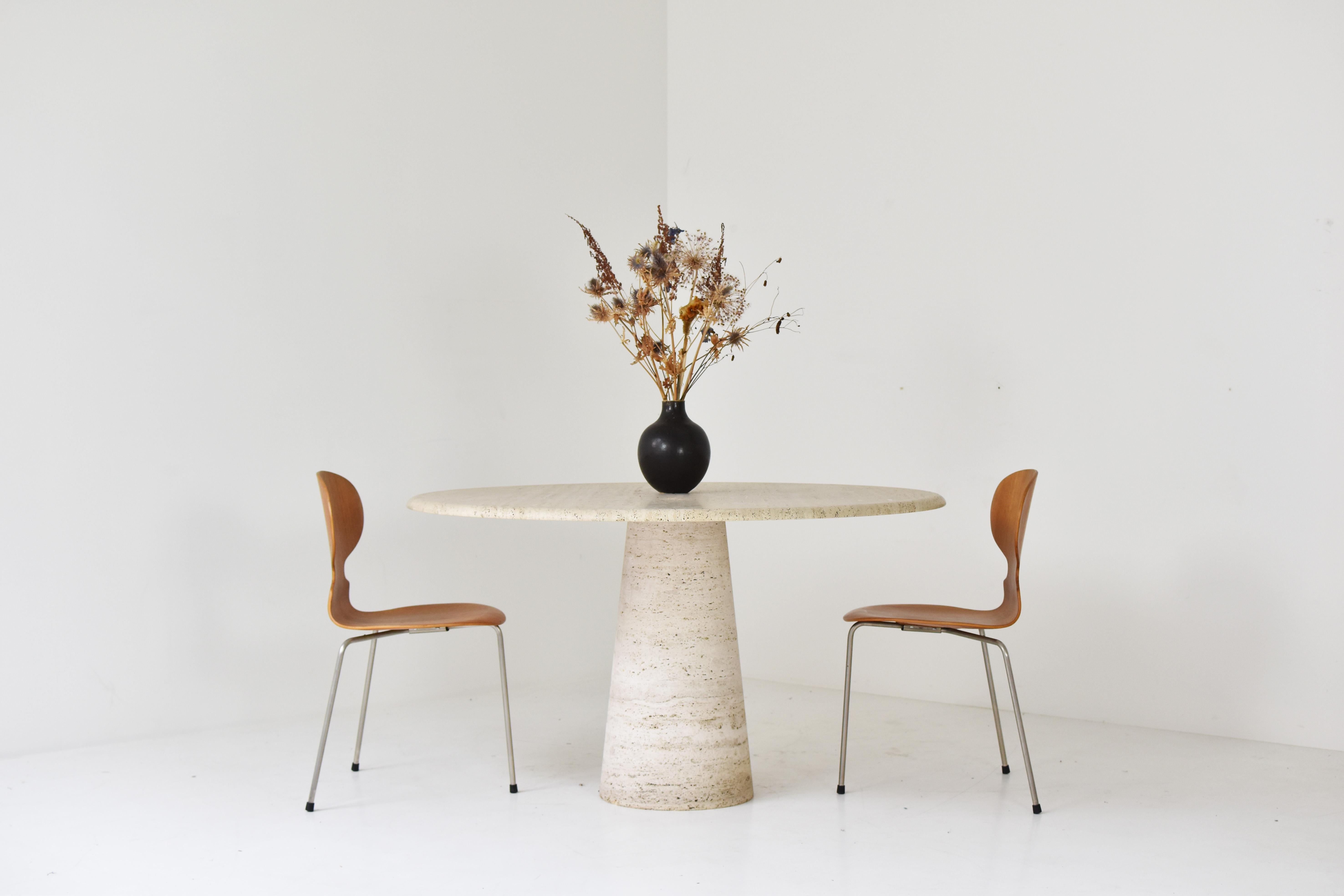 Travertine dining table by Up & Up, Italy 1970’s. The table is fully made out of travertine with variegated tones of beige and brown. The top rests on a unique cylinder shaped pedestal base. Very well presented original condition with only minor