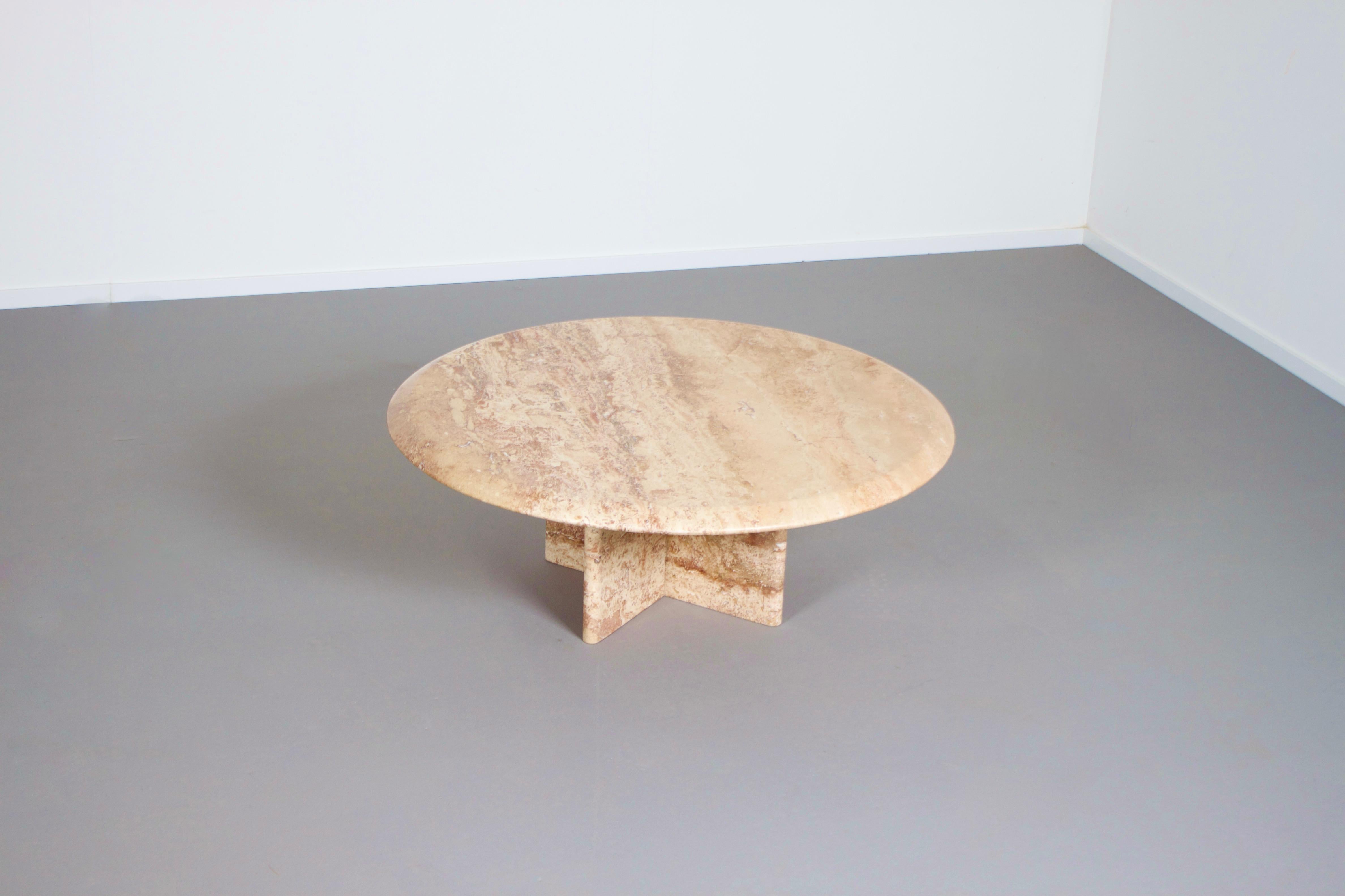 Round travertine coffee table in very good condition. 

Manufactured by Up&Up Italy in the 1970s 

The table has a round travertine top which has a beautiful colours, such as beige, brown, dark red and pink.

The base is formed of four slabs of