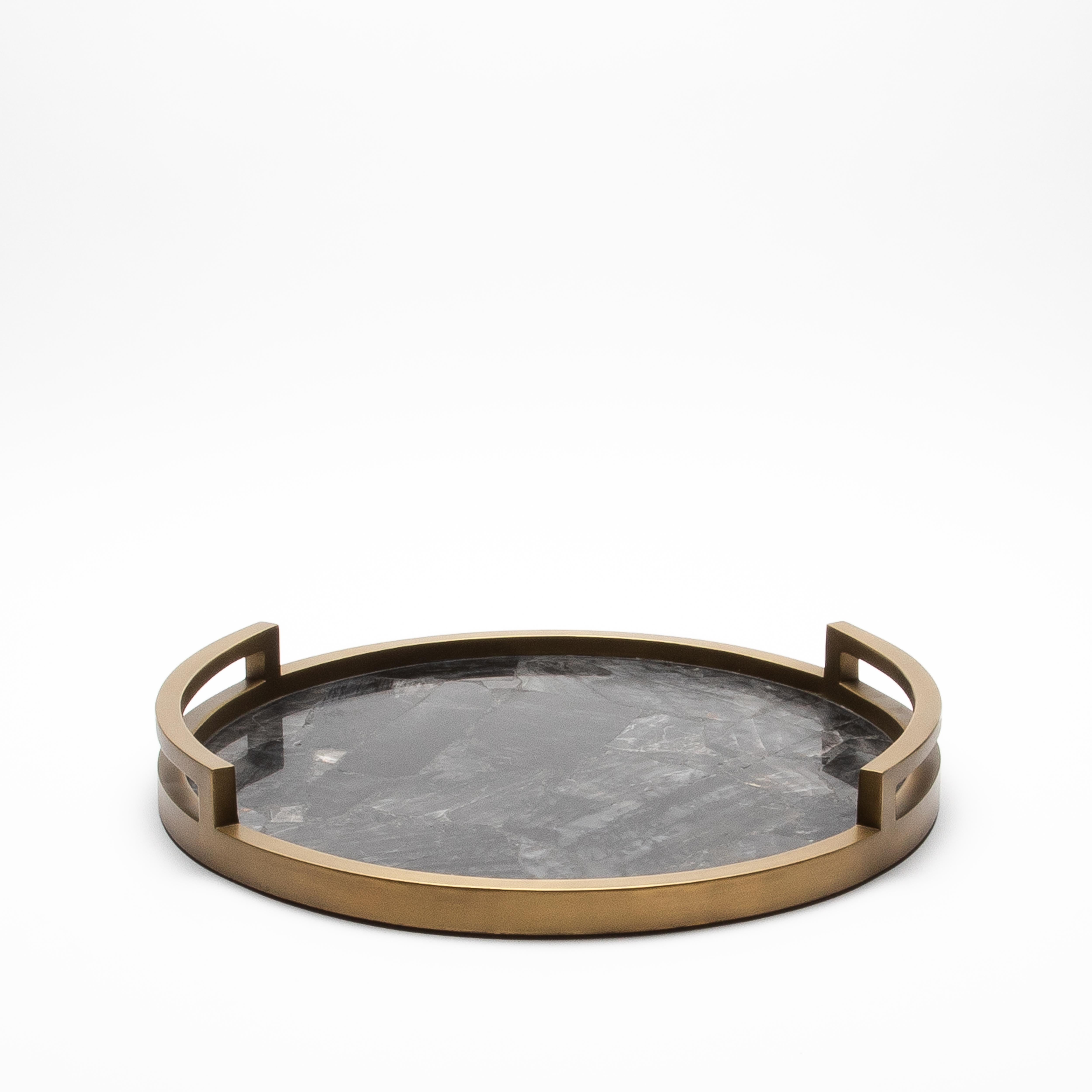 This exquisite Round Tray in Black Quartz with Bronze Patina Brass by R&Y Augousti is a luxurious accent for any refined space. The striking contrast between the deep, rich tones of the hand-selected black quartz and the warm glow of bronze patina