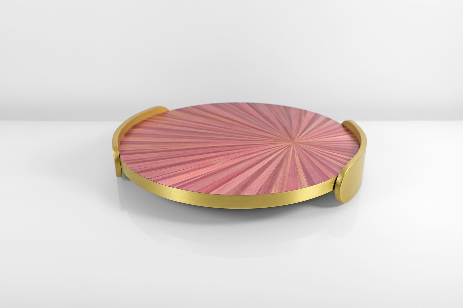 Ce joli plateau rond rose est en laiton brossé et en marqueterie de paille.
Le design radial de la paille rappelle la grande période Art déco tandis que l'élégante couleur rose contraste parfaitement avec le laiton doré.

La paille utilisée pour la