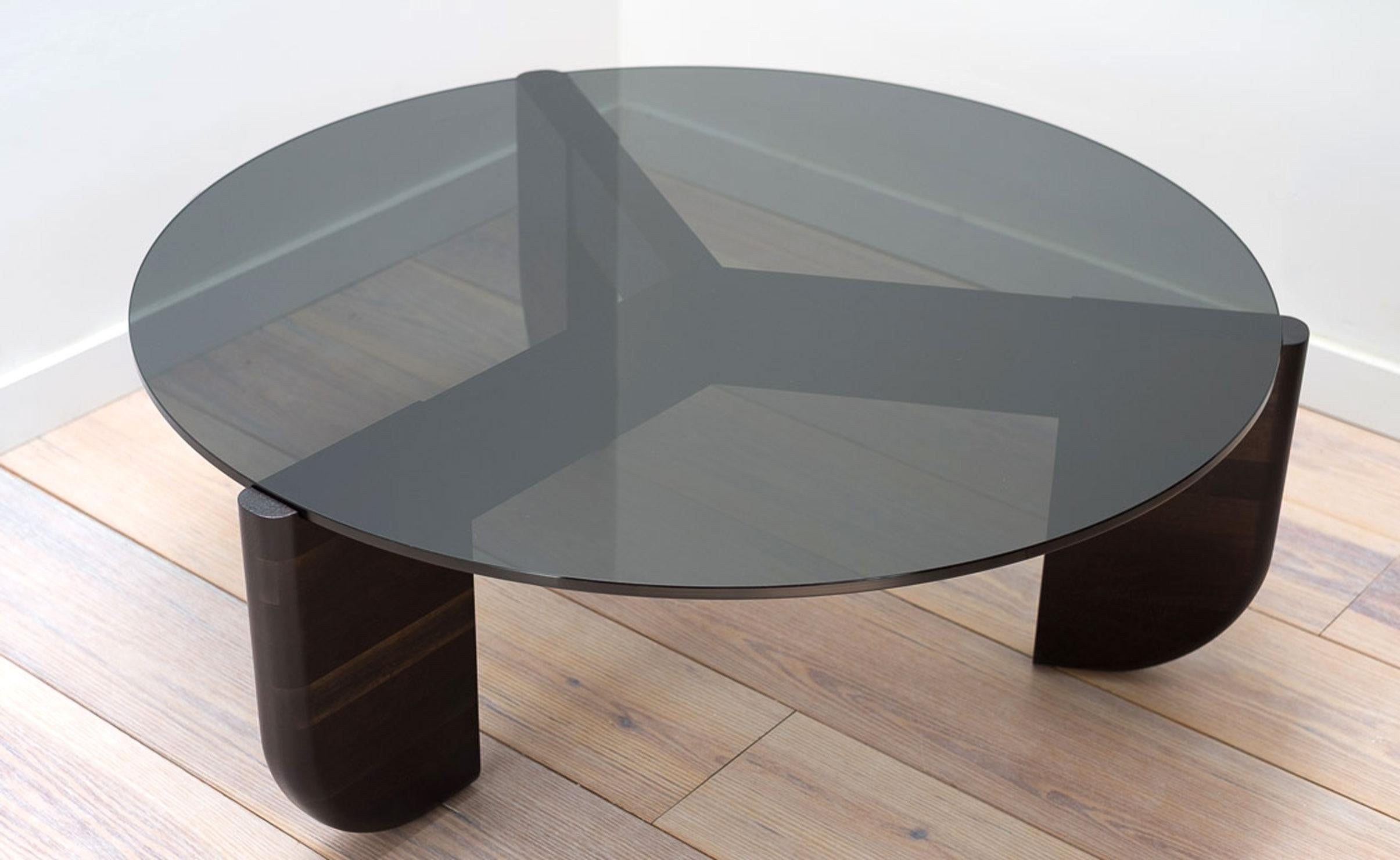 The Tripod Coffee Table is an exploration of material, texture, and form. The base and top were designed to fit together as one, with the bottom curve of the glass seated neatly in the inverse curve of the wooden legs. This piece is artisan-made in