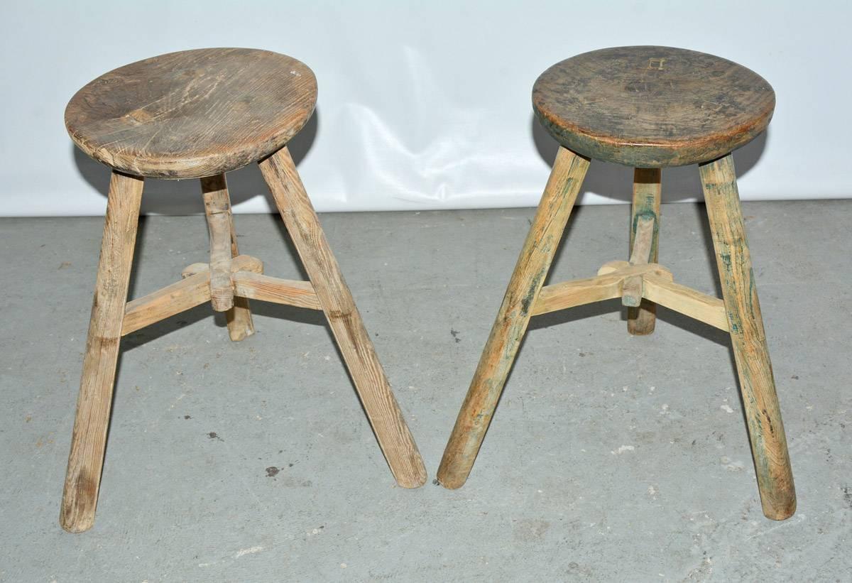 Each of the two vintage rustic Chinese elmwood stools from the Qing Dynasty has three legs with stretchers that join at the centre. The legs are pegged to the full thickness of the seat for sturdy construction.
Each stool is slightly different in