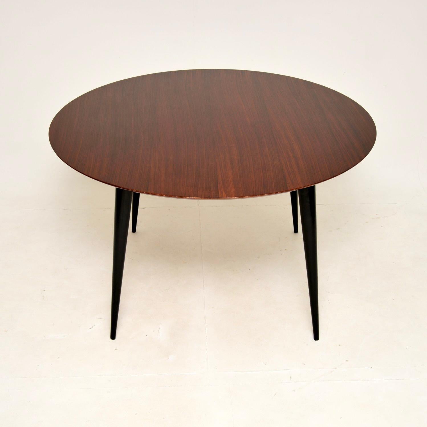 A gorgeous vintage dining table, made in England and dating from the 1960’s.

This is of superb quality, the beautiful circular top has lovely chamfered edges. This sits on stunning tapered legs which are ebonised wood.

We have had this stripped
