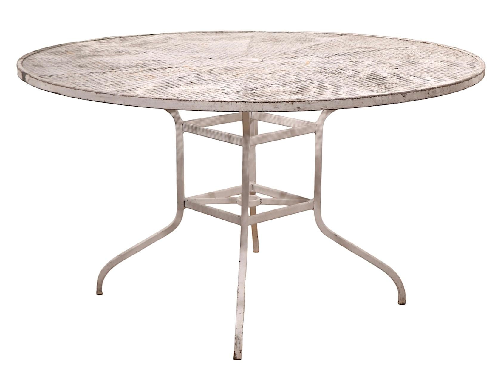 Table de jardin vintage, patio, piscine, avec un plateau rond en maille métallique, sur des pieds en métal quadrillé. Cette belle grande table est en très bon état, propre, d'origine et prête à l'emploi, présentant une légère usure cosmétique de la
