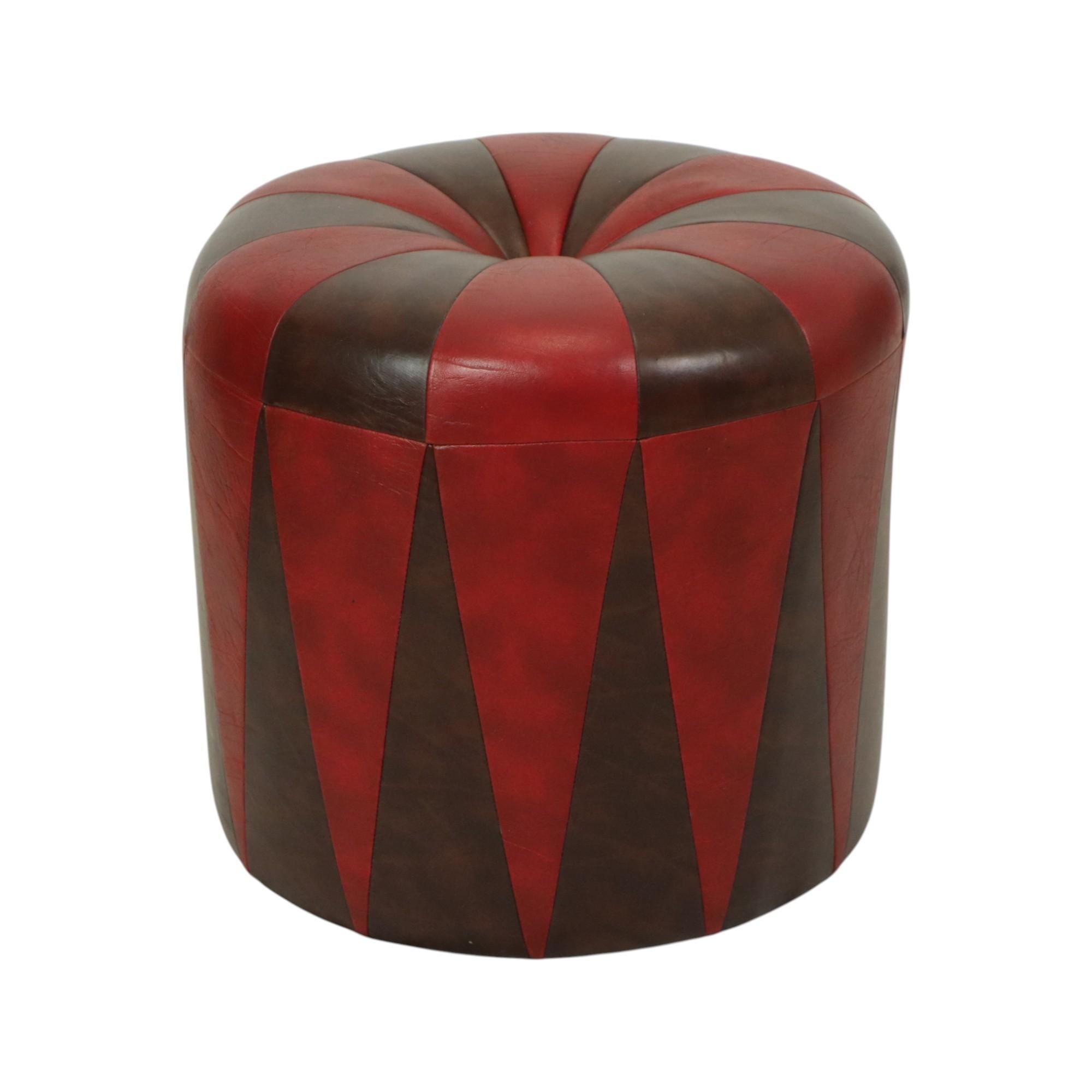Cooler runder Vintage-Ottoman im Patchwork-Stil mit Holzsockel und hochwertigem, zweifarbig dunkelbraun und rot marmoriertem Kunstlederbezug, hergestellt in Belgien um die 1960er Jahre.

Ein charaktervolles und authentisches Stück aus den 1960er