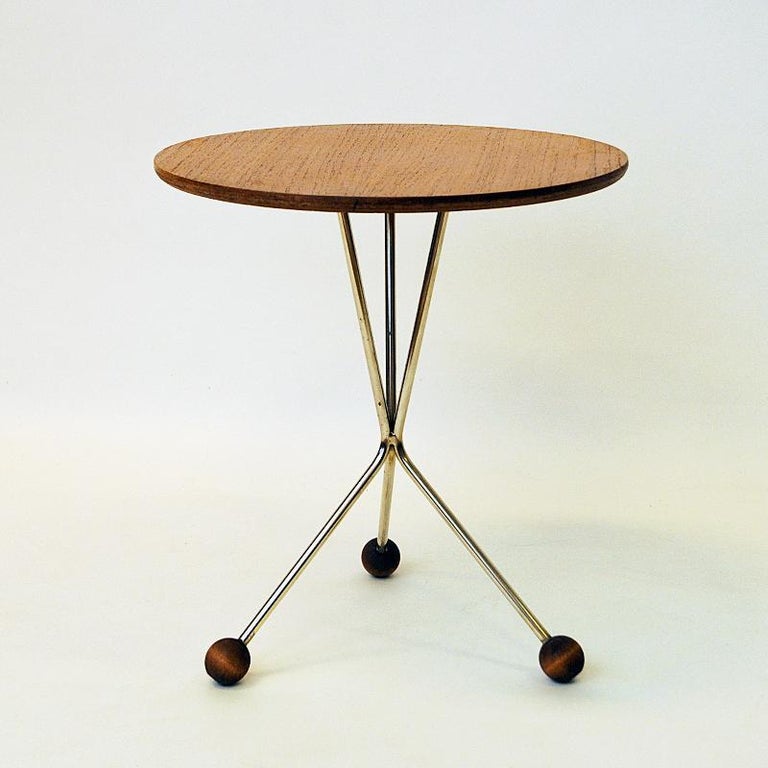 A lovely midcentury coffee or side table with a round teak top plate and metal legs underneath with three rounded teak ball legs. Designed by Albert Larsson for Tibro Möbelfabrik in the 1950s Sweden.
This funny little tables original name was model