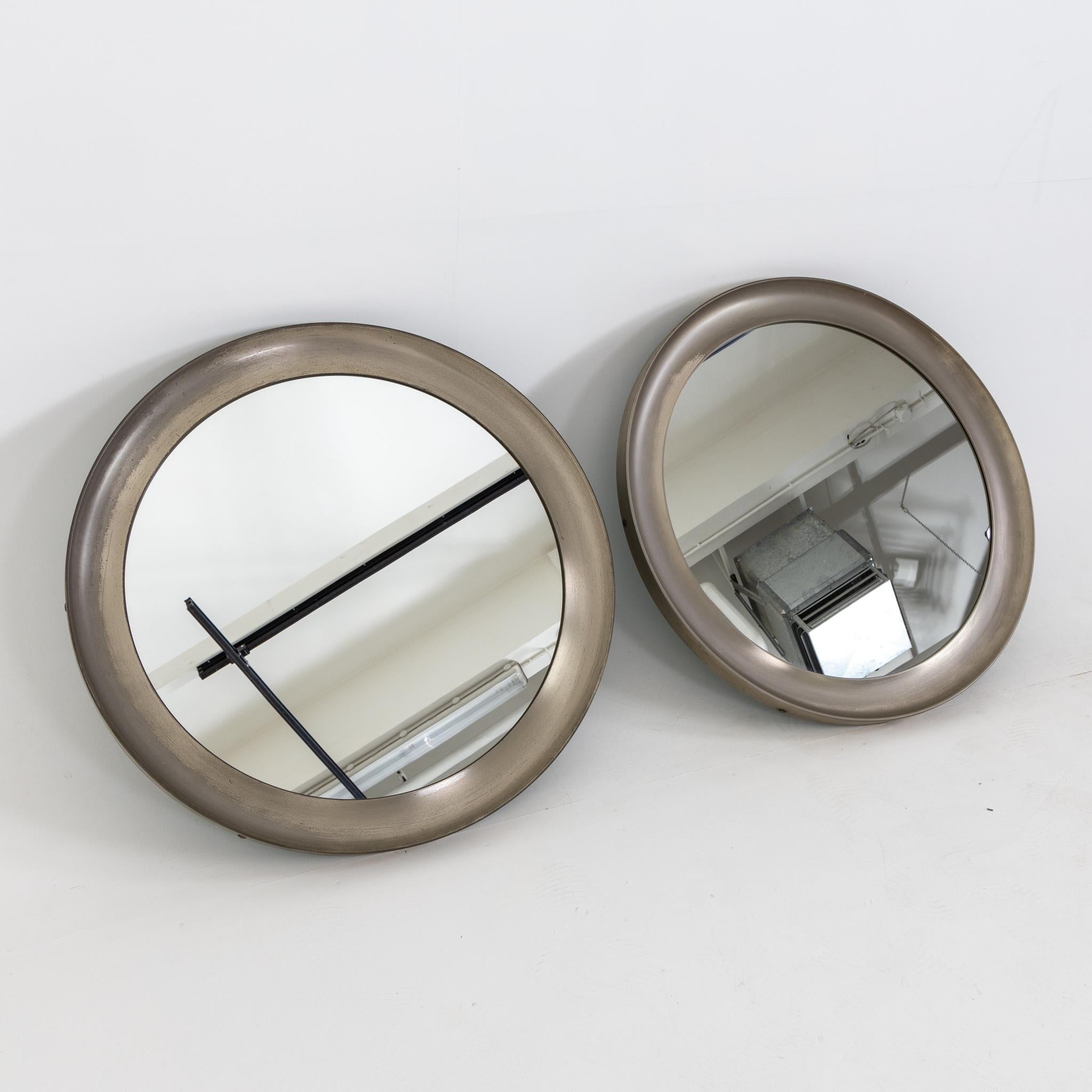 Two round wall mirrors with smooth metal frames with slight fillet.