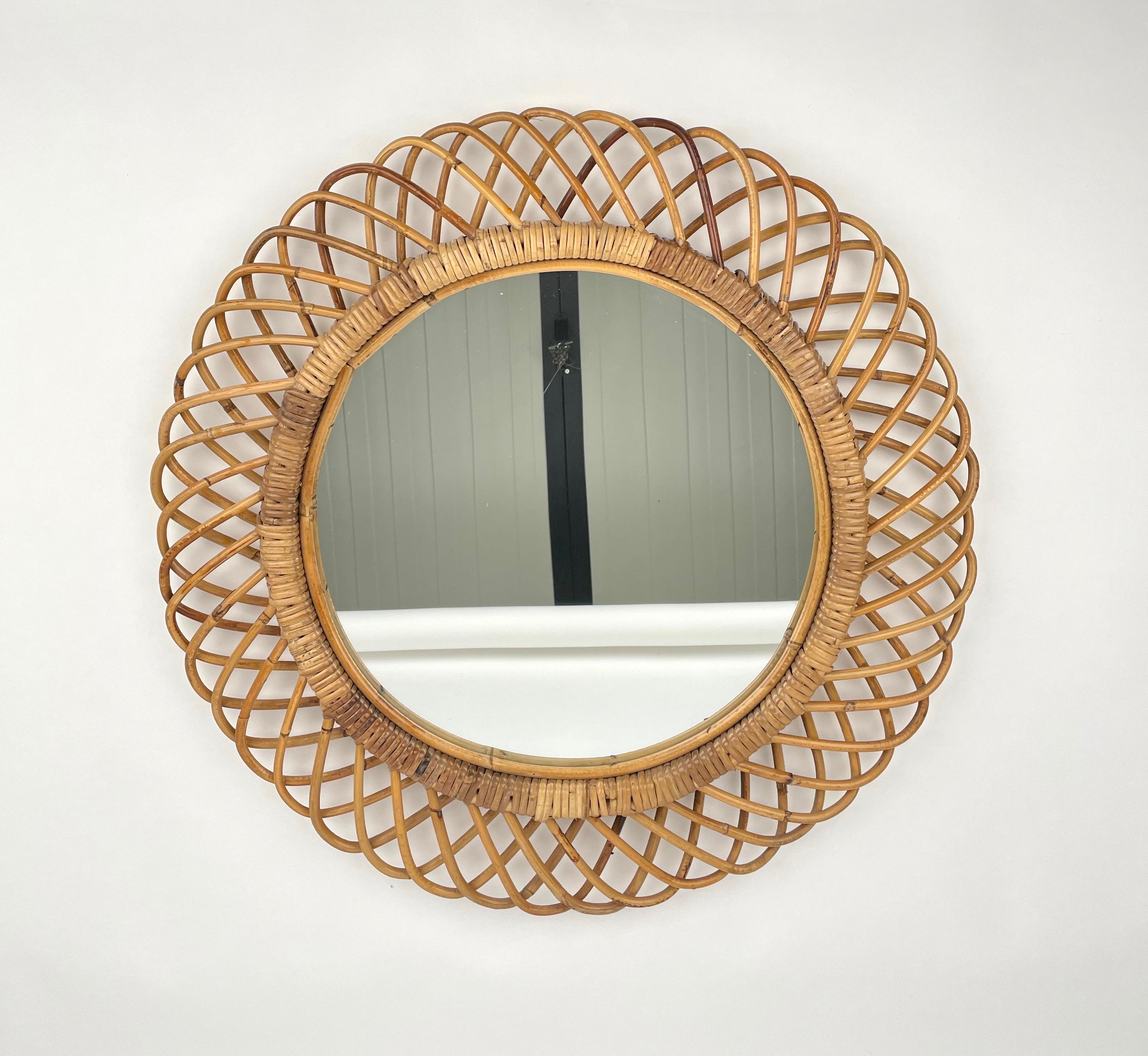 Midcentury Italian Riviera rattan and bamboo round mirror, 1960s.

This wall mirror is unique as it has a curved rattan beam and bamboo double frame, a solid internal one and an external one make of geometric patterns.