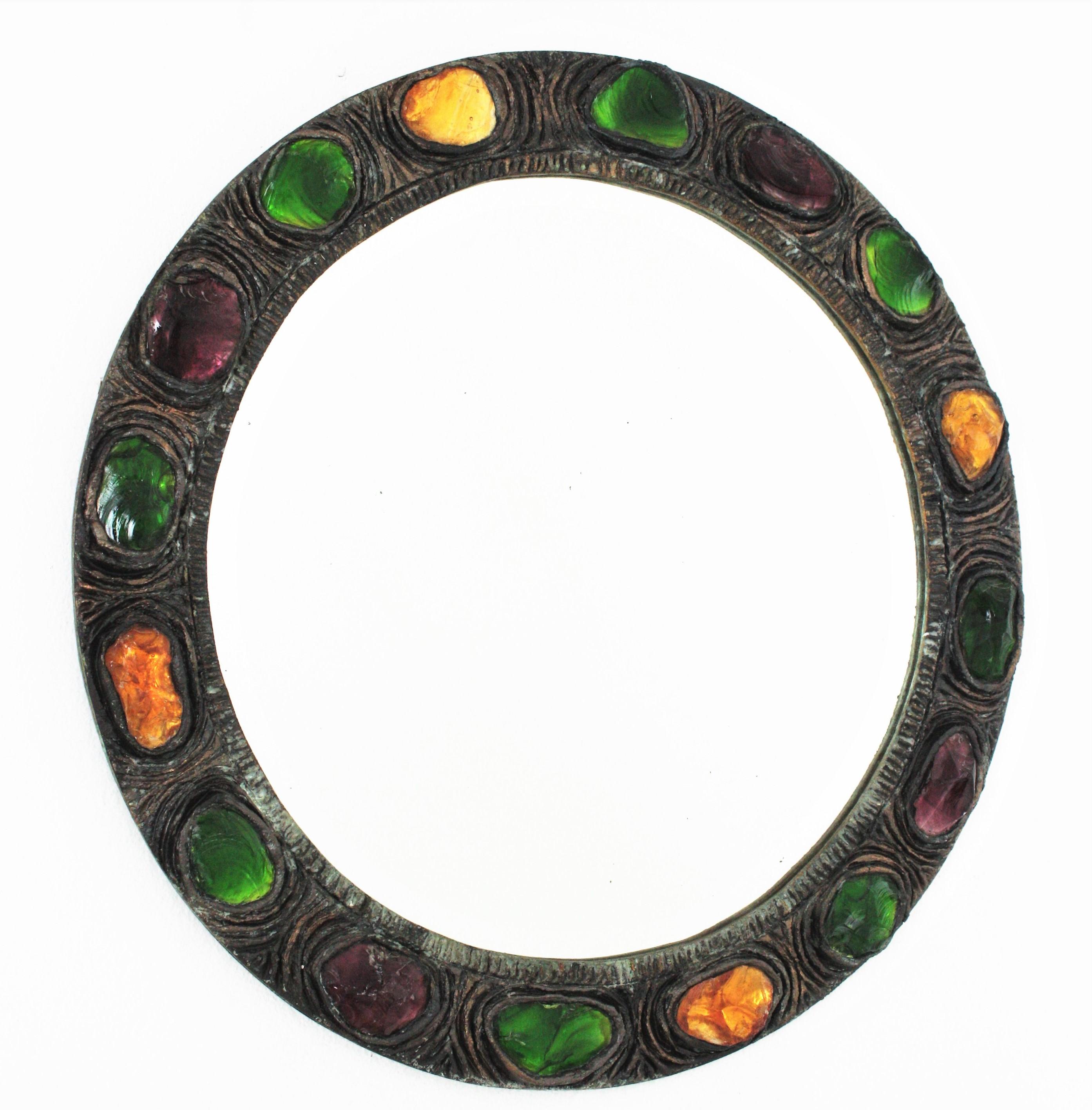Rare Mid-Century Modern handcrafted circular mirror made of stucco accented with green, yellow, orange and purple rock crystals . Spain, 1960s.
Beautiful frame made with pieces of colorful rock crystals and silver patinated finish. Lovely to be