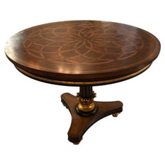 Round walnut center table with marquetry top and gilt accents