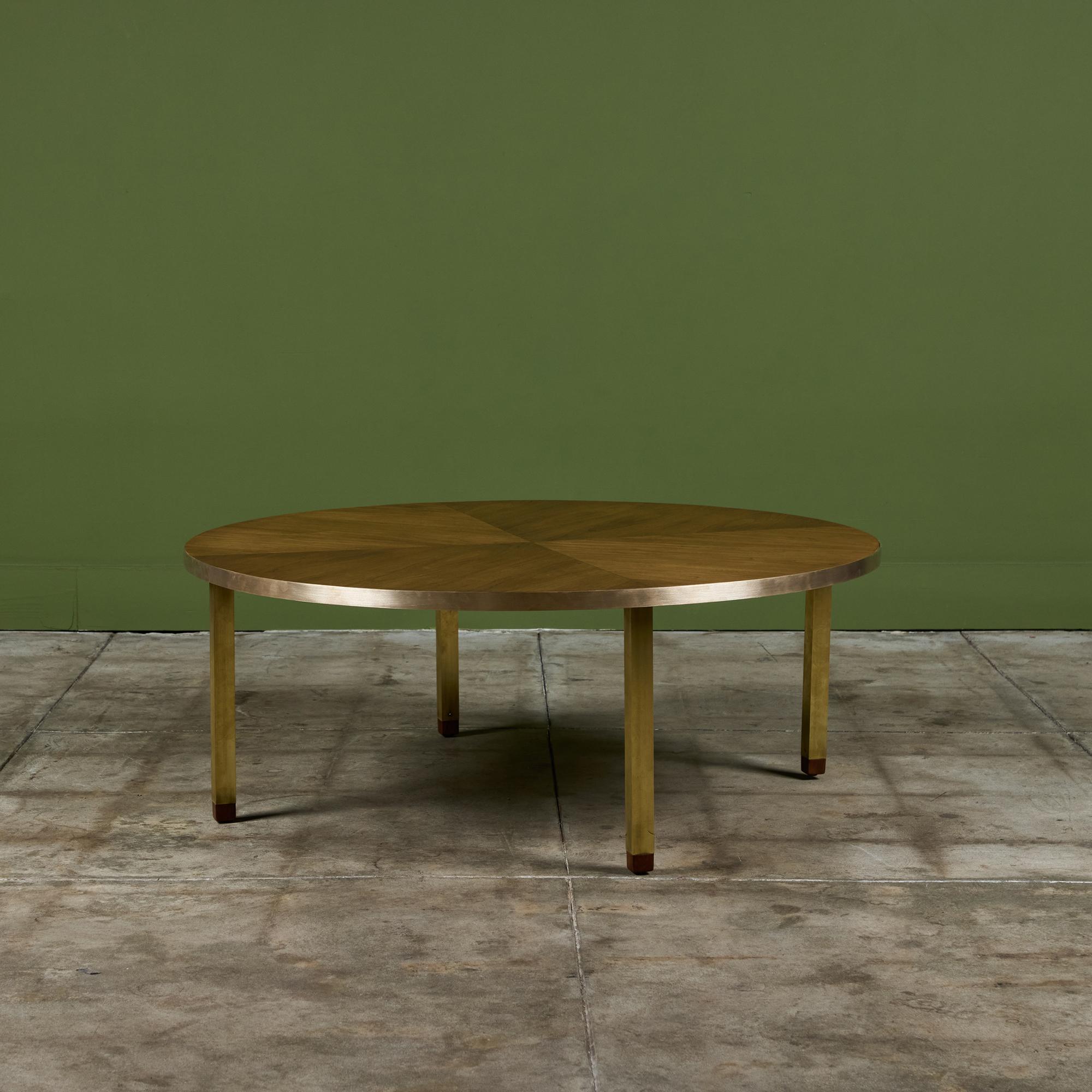 Cette table basse ronde en noyer est ornée d'un bord en laiton non laqué et de quatre pieds carrés en laiton surmontés d'un cachet en noyer. Le plateau de la table présente un magnifique noyer à quatre panneaux assortis.

Dimensions
42,25
