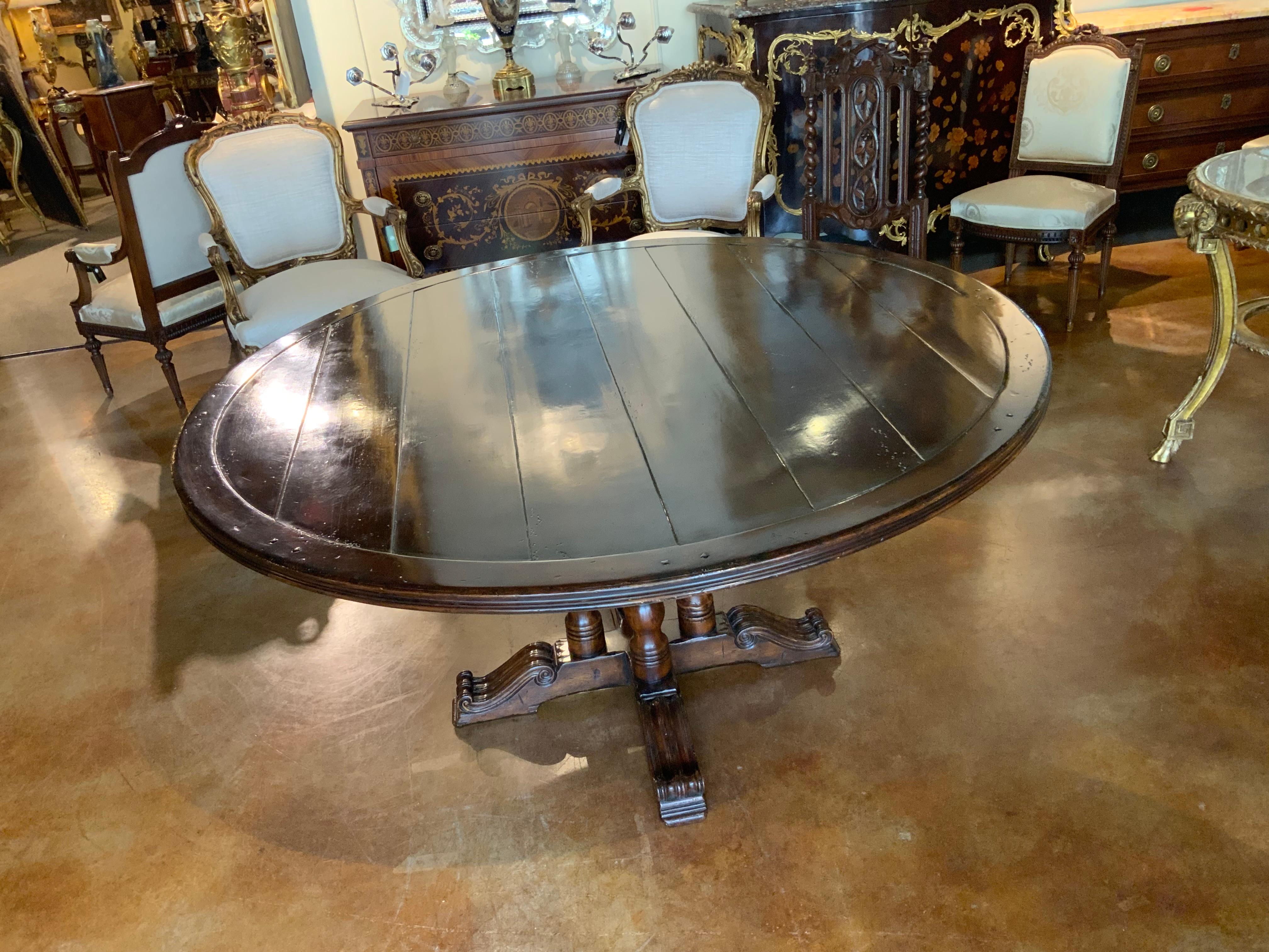 This is a handsome table with a distressed finish to look aged
With light distressing and peg marks. It has multiple planks that
Run horizontally across the table top. It has four legs that are
Centered for support and has four curved and scrolling