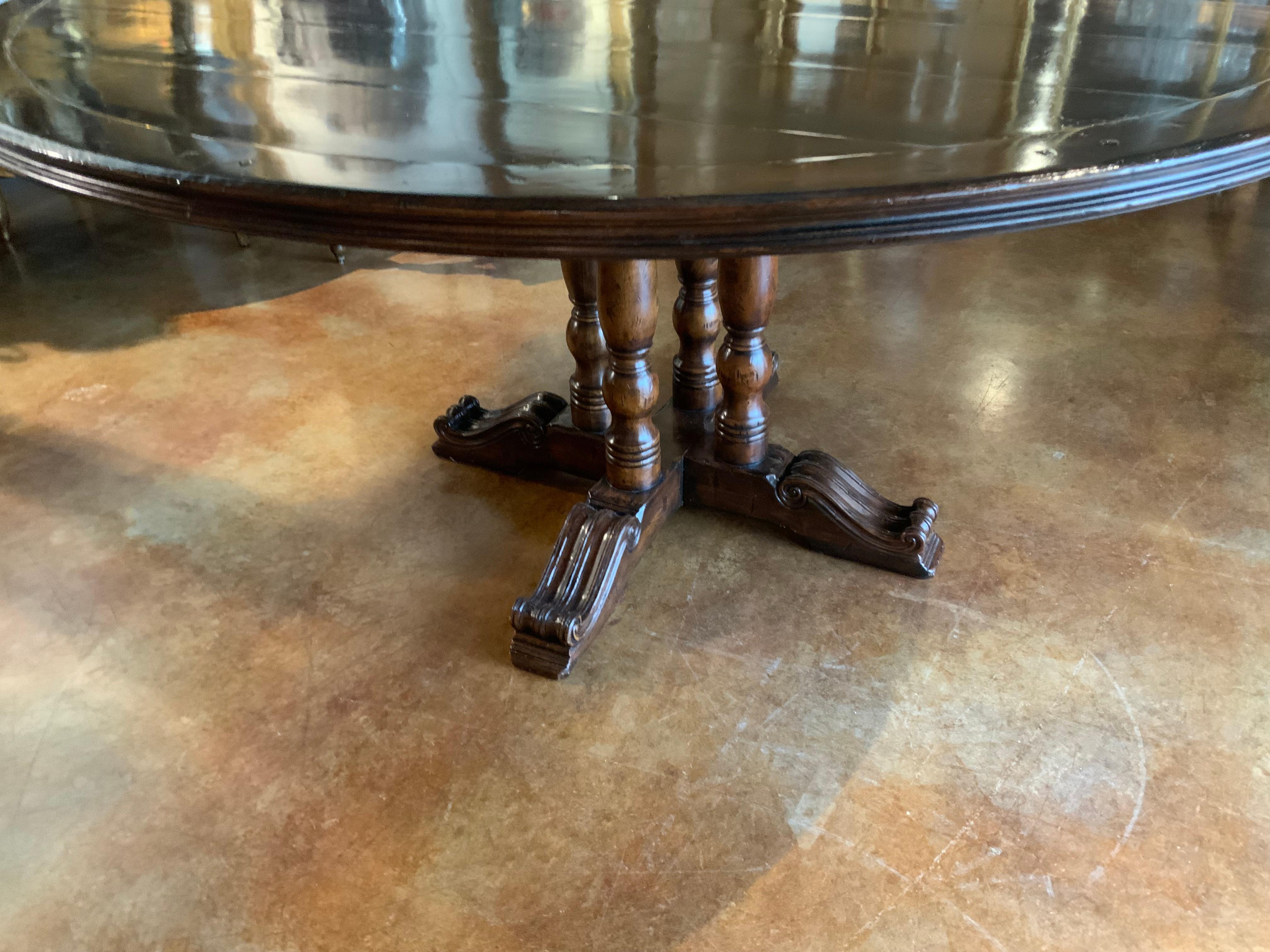 American Round walnut dining table on a pedestal Four post carved leg, 60” diameter 