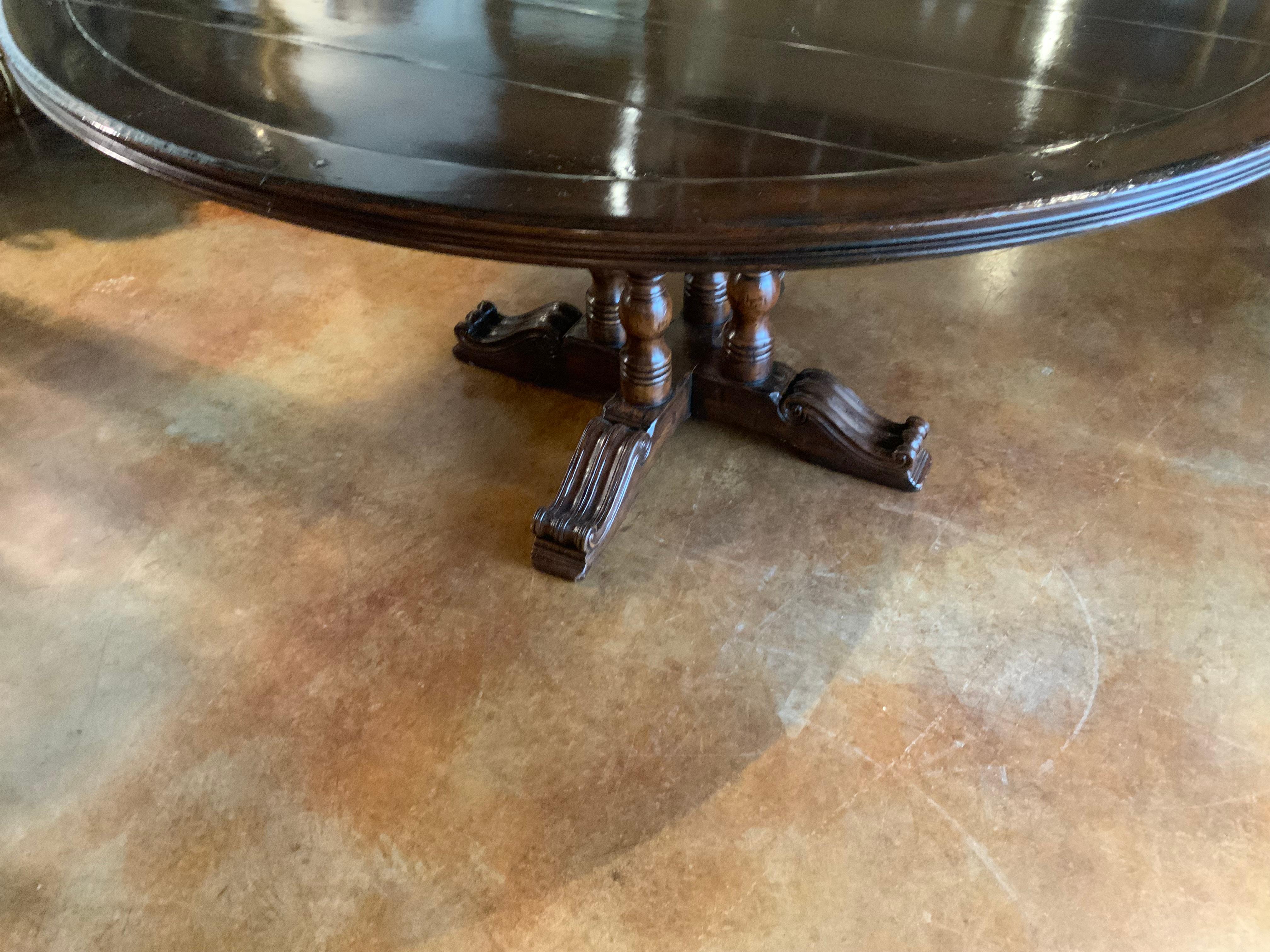Round walnut dining table on a pedestal Four post carved leg, 60” diameter  In Good Condition In Houston, TX
