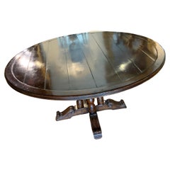 Round walnut dining table on a pedestal Four post carved leg, 60” diameter 