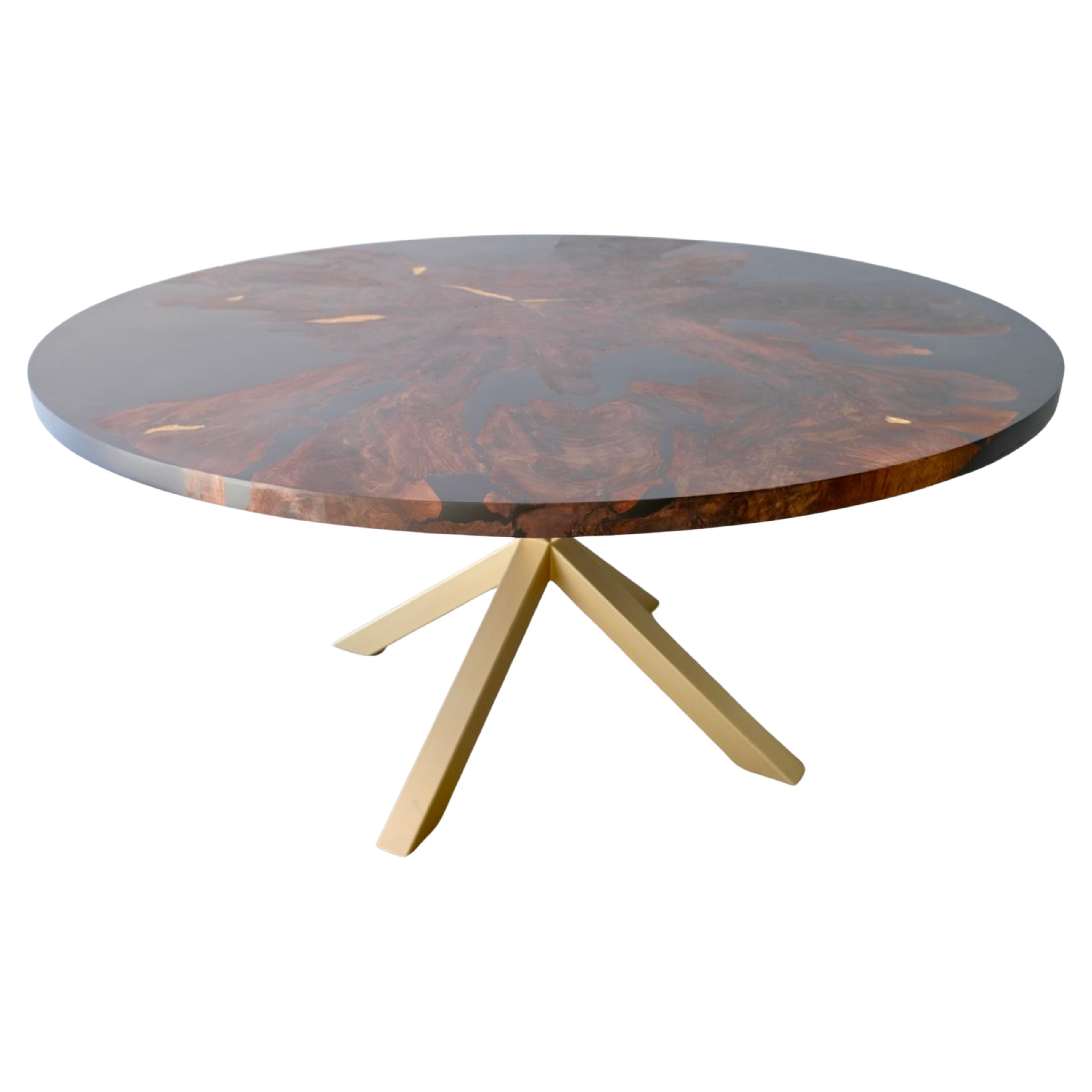 Heirloom quality, this dining table is handmade from a single slab of solid walnut and features a beautiful grain. 
The slab is reinforced and surrounded with a black resin epoxy. The table features small gold epoxy details and a steel frame.