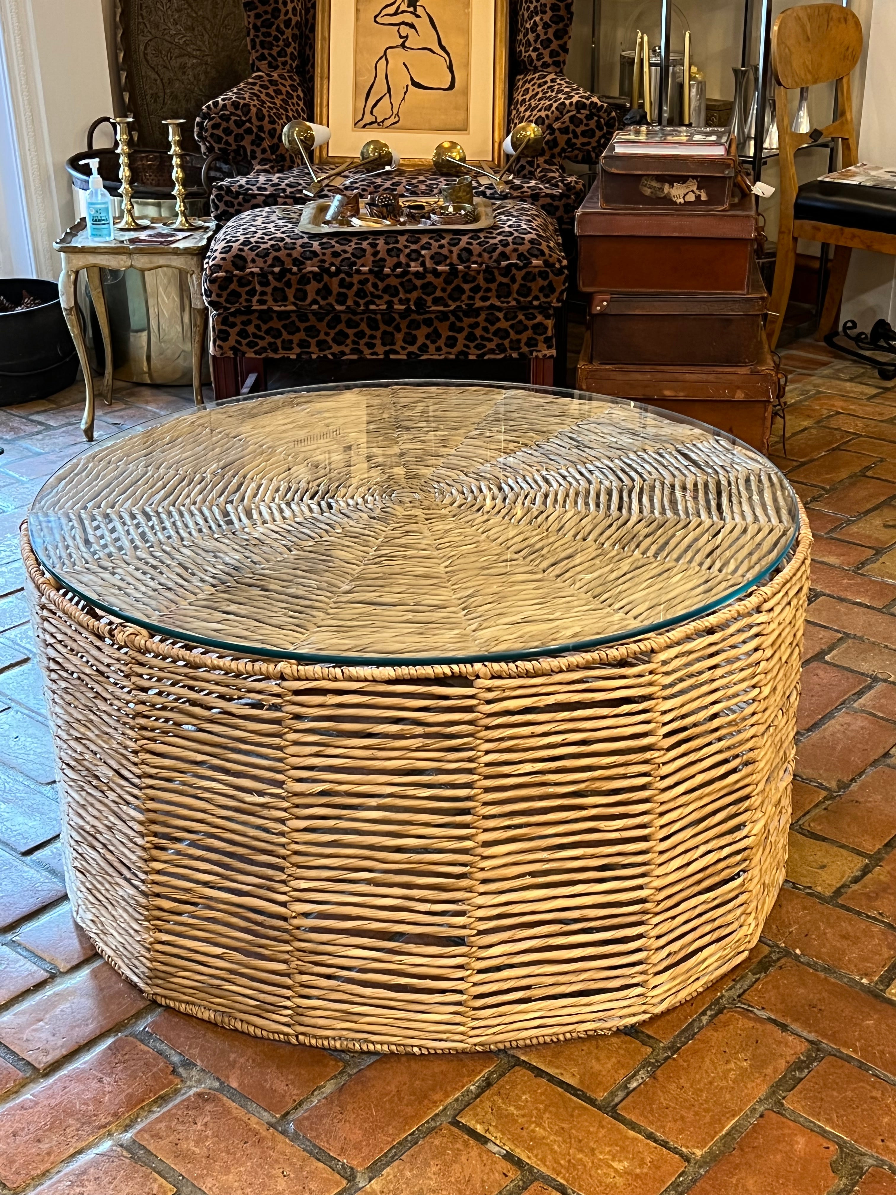 Mesa de centro redonda de hierba marina con tablero de cristal. Un look boho chic estupendo. 